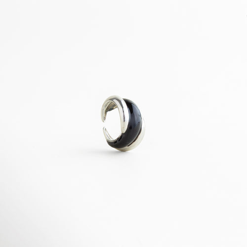 Vista inclinada del Anillo Nerisse con diseño orgánico y acabado plateado brillante, Anillo moderno en tono plata visto en ángulo con forma envolvente y elegante, Vista diagonal de anillo statement con silueta curva y estilo contemporáneo, Anillo femenino con diseño audaz y acabado en Oro Blanco visto en perspectiva, Detalle angular del Anillo Nerisse con líneas suaves y apariencia sofisticada.