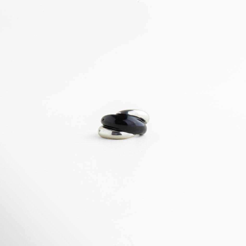 Anillo Nerisse en tono plateado con diseño orgánico y contraste audaz, Anillo moderno de cobre con recubrimiento en Oro Blanco y estilo sofisticado, Anillo abierto con silueta envolvente y acabado brillante en tono plateado, Anillo femenino de diseño contemporáneo con forma curva y elegante, Anillo statement plateado con estética minimalista y mucha personalidad.