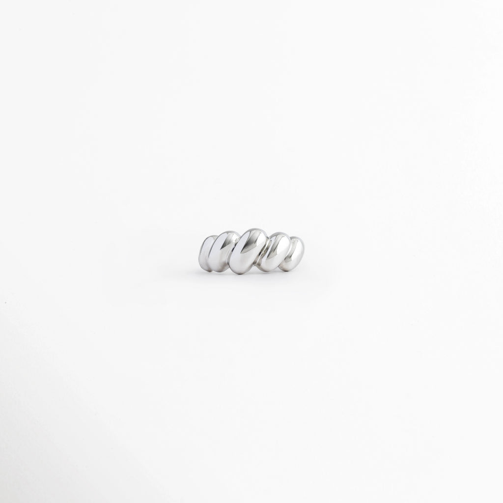 Anillo Virella de cobre con acabado plateado de pulido brillante y diseño entrelazado sobre fondo b, Vista frontal del Anillo Virella con diseño geométrico de bandas entrelazadas y acabado brillante, Anillo Virella con diseño moderno de aros entrecruzados y acabado plateado, Anillo Virella ajustable de cobre con acabado pulido brillante y estilo contemporáneo, Anillo plateado Virella con diseño entrelazado de líneas curvas y acabado brillante.