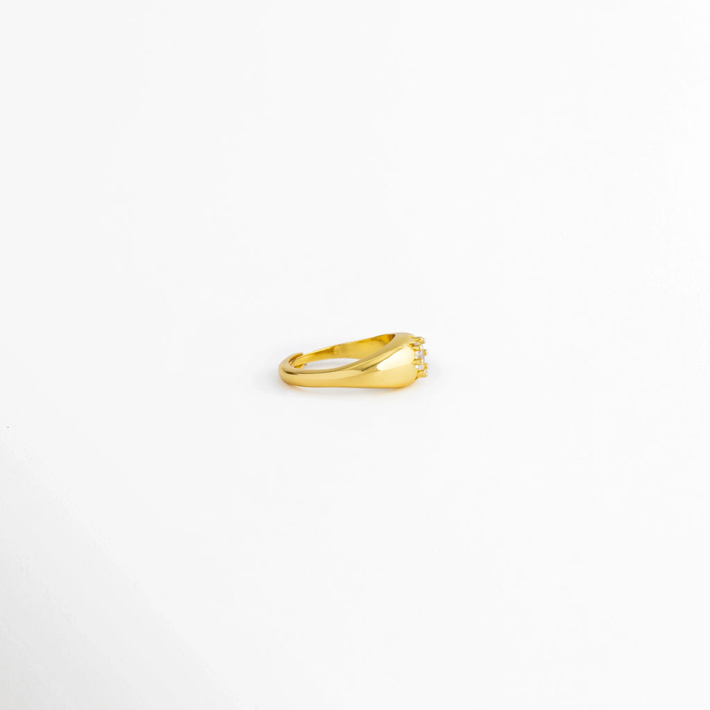 Vista lateral del Anillo Sirius con diseño ajustable y zirconia central, Perfil del Anillo Sirius elaborado en cobre con acabado brillante, Anillo Sirius visto de lado mostrando el engaste de la zirconia, Vista lateral del anillo dorado Sirius con diseño minimalista, Perfil del Anillo Sirius con recubrimiento pulido brillante.