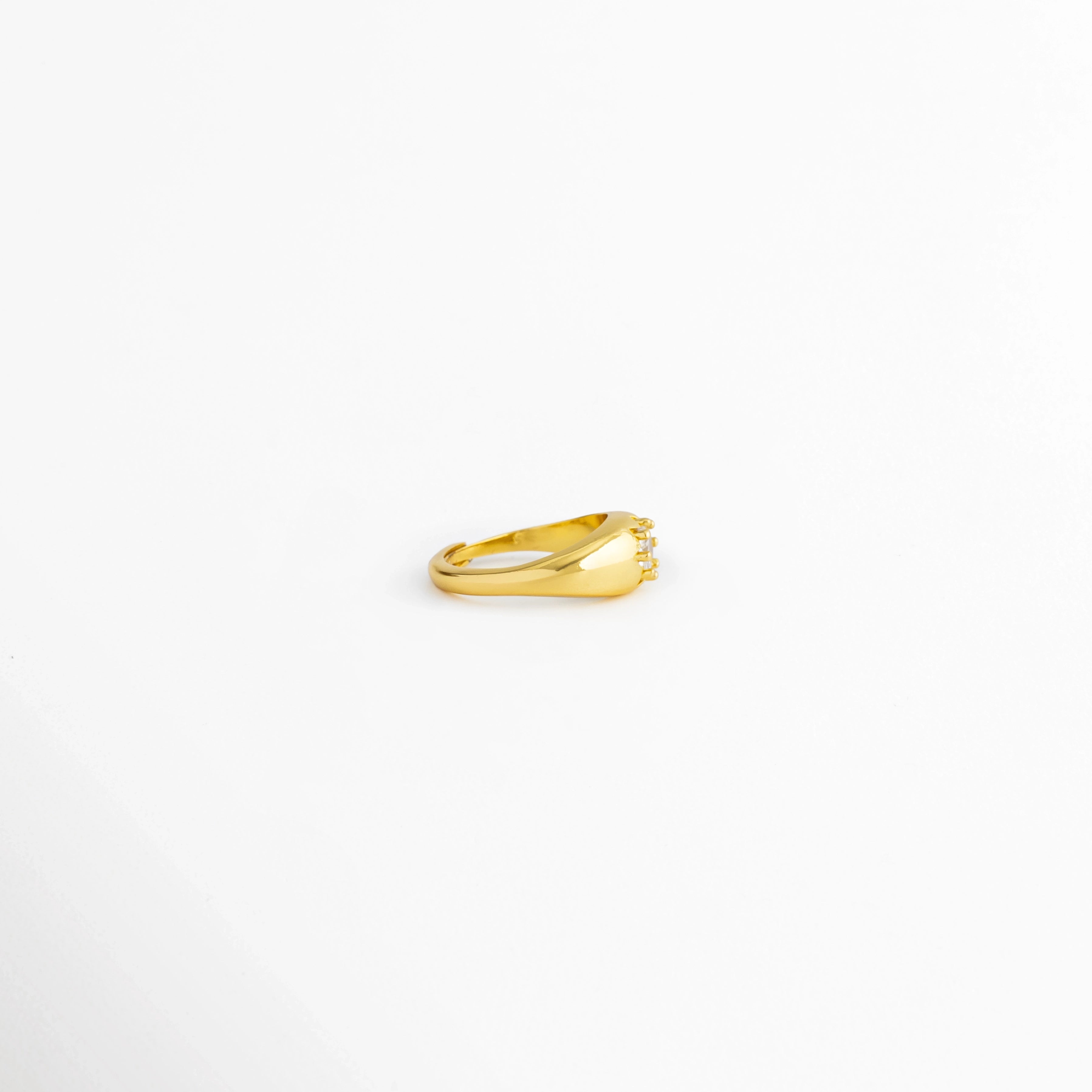 Vista lateral del Anillo Sirius con diseño ajustable y zirconia central, Perfil del Anillo Sirius elaborado en cobre con acabado brillante, Anillo Sirius visto de lado mostrando el engaste de la zirconia, Vista lateral del anillo dorado Sirius con diseño minimalista, Perfil del Anillo Sirius con recubrimiento pulido brillante.