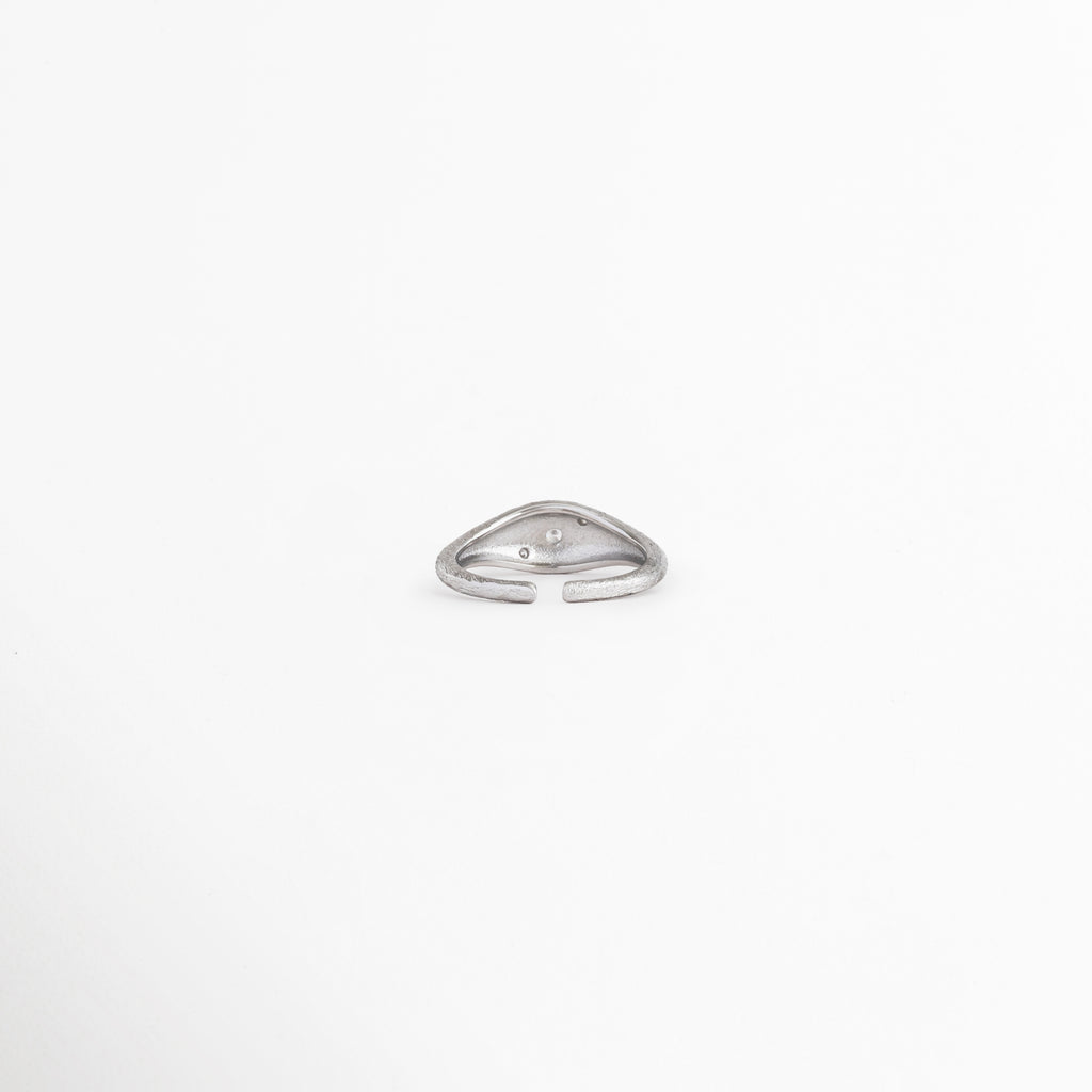 Vista superior de anillo Silver Solaris con zirconia central, Anillo plateado ajustable con diseño elegante y minimalista, Detalle superior de anillo con incrustación de zirconia, Anillo moderno con acabado brillante y forma estilizada, Vista de anillo Silver Solaris con detalle central luminoso.