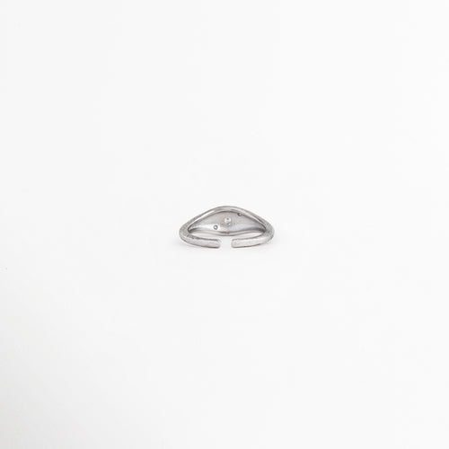 Vista superior de anillo Silver Solaris con zirconia central, Anillo plateado ajustable con diseño elegante y minimalista, Detalle superior de anillo con incrustación de zirconia, Anillo moderno con acabado brillante y forma estilizada, Vista de anillo Silver Solaris con detalle central luminoso.