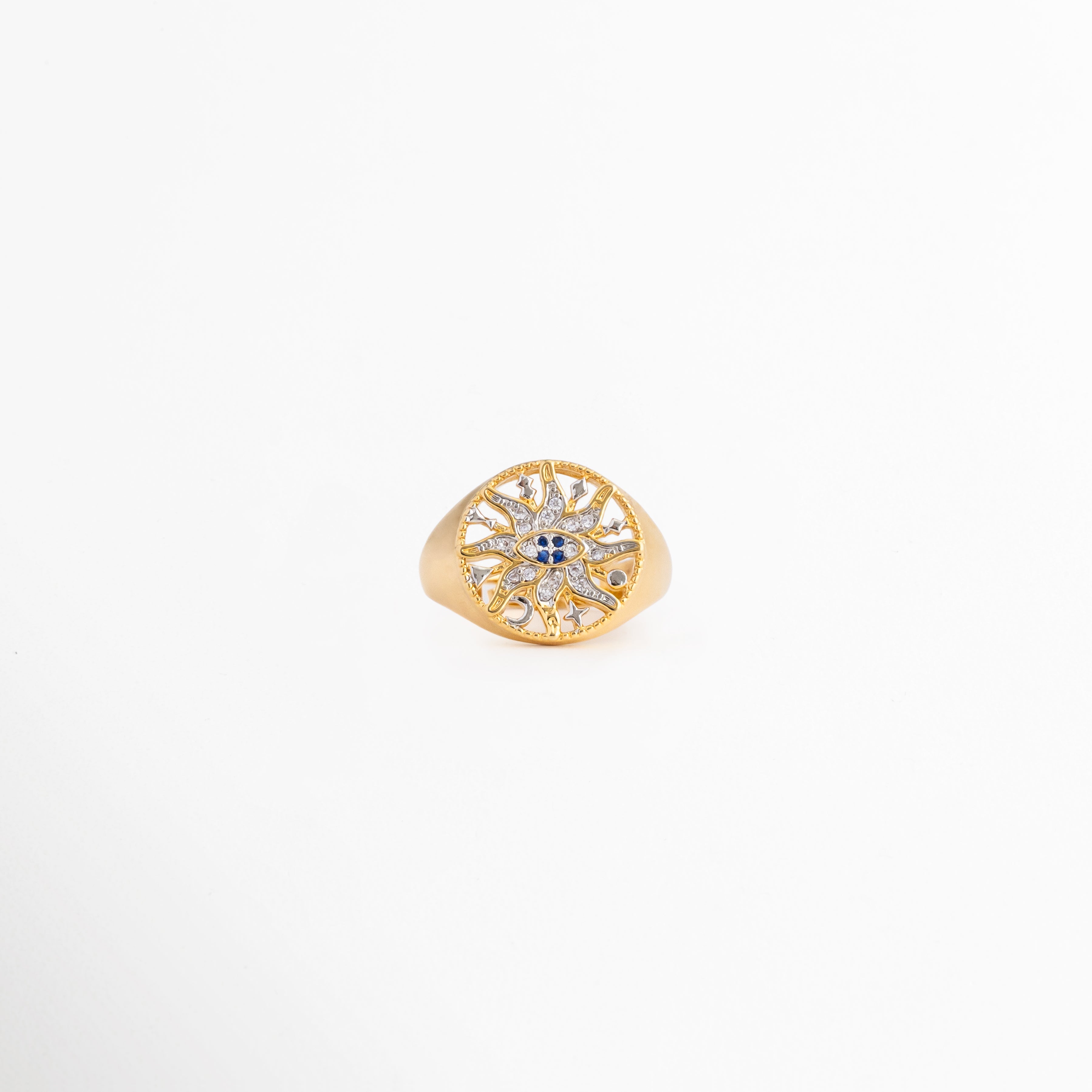 Anillo Alaric dorado tipo sello con diseño calado de sol y zirconias, Anillo ajustable chapado en oro de 14K con patrón místico de estrella brillante, Joyería fina para mujer: anillo dorado con pedrería fina y centro azul sobre fondo blanco, Vista frontal de anillo místico con zirconias incrustadas y detalles calados, Anillo de cobre bañado en oro con diseño celestial redondo y brillante.