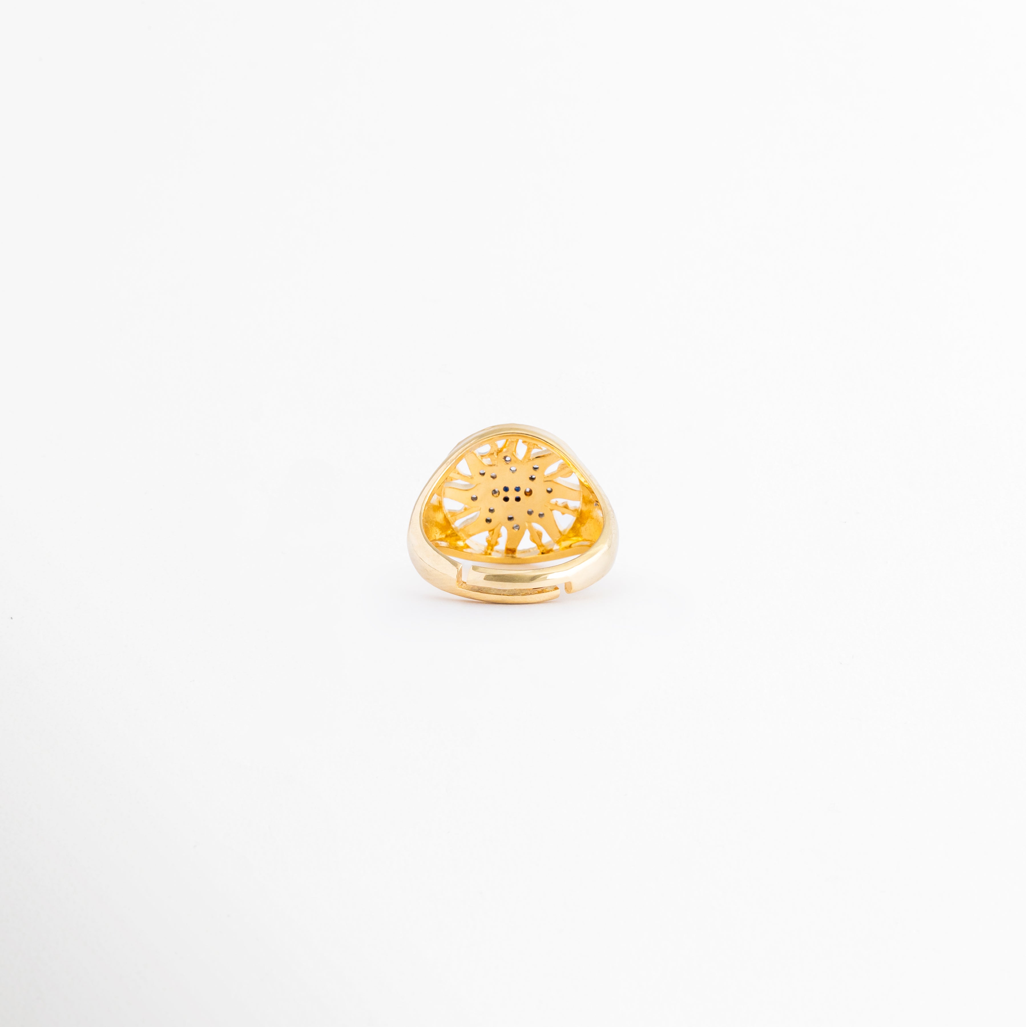 Vista inferior del anillo Alaric destacando su diseño abierto y ajustable, Detalle de la parte trasera regulable del anillo chapado en oro para adaptarse a cualquier talla, Sistema de apertura de la banda del anillo para un ajuste ergonómico y cómodo, Primer plano de la terminación trasera abierta de la joyería de cobre dorada, Banda ajustable del anillo místico de sol fotografiada desde atrás.