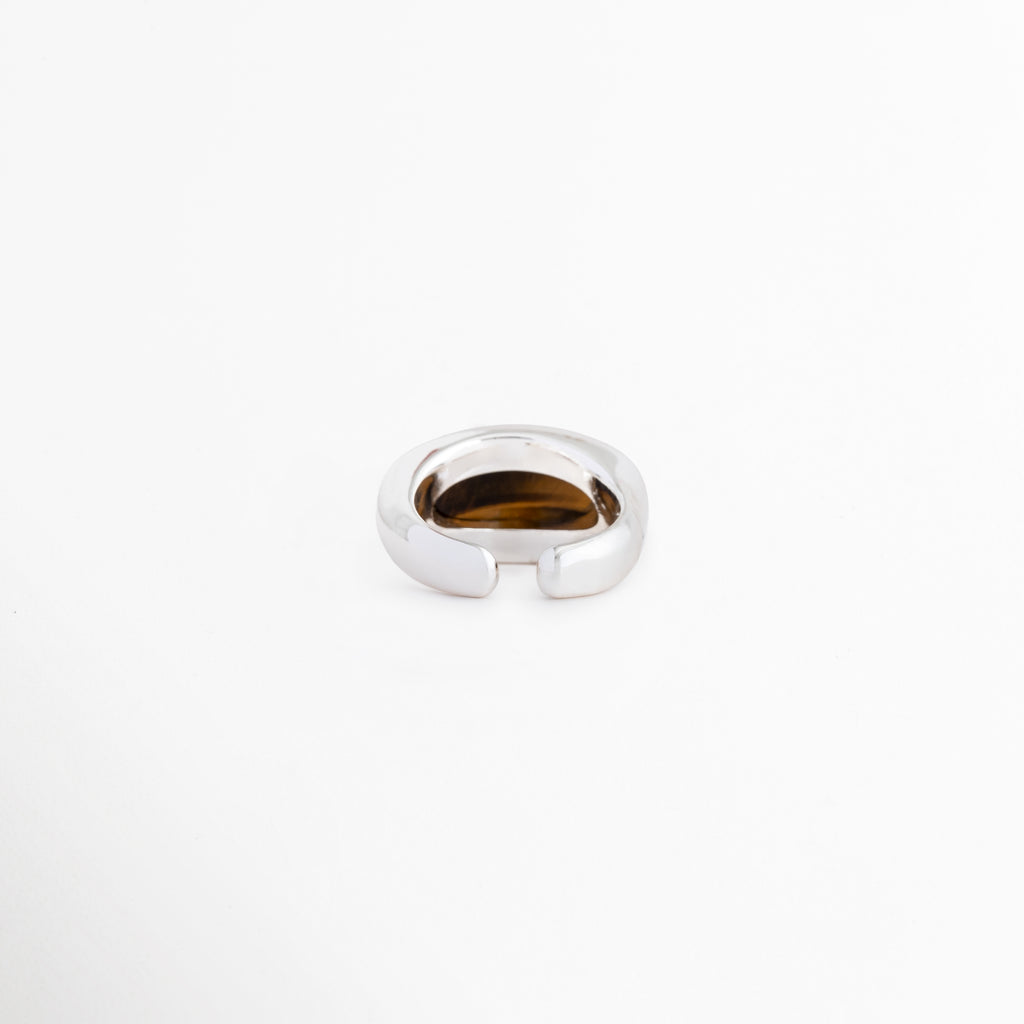 Detalle de la parte posterior abierta del anillo Kaio que permite ajustar la talla, Vista inferior de la banda del anillo ajustable chapado en oro blanco, Sistema de apertura regulable del anillo de cobre para adaptarse a cualquier dedo, Primer plano del diseño abierto y ergonómico del anillo plateado de mujer, Terminación de la banda ajustable del anillo con recubrimiento de oro blanco.
