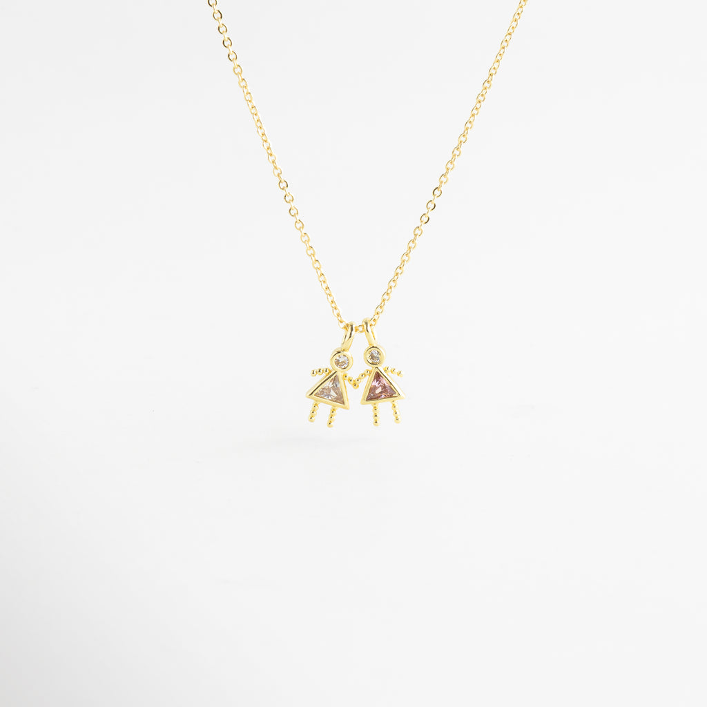 Dije dorado de niña con zirconia cristal en diseño delicado, Detalle de colgante con piedra transparente y figura femenina minimalista, Collar con dije pequeño de niña y zirconia cristal brillante, Colgante en oro 18K con zirconia transparente y acabado pulido, Detalle de collar con figura decorativa y piedra cristal