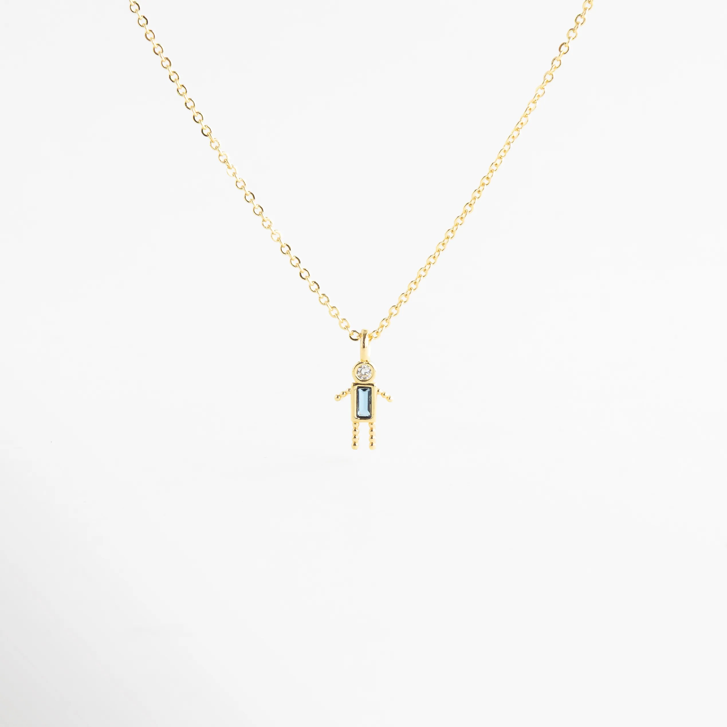 Collar dorado con dije de niño y zirconia celeste brillante, Collar delicado con colgante de niño y piedra celeste elegante, Collar en oro 18K con dije de niño y zirconia celeste, Collar fino dorado con figura de niño y detalle celeste, Collar con colgante pequeño de niño y zirconia celeste