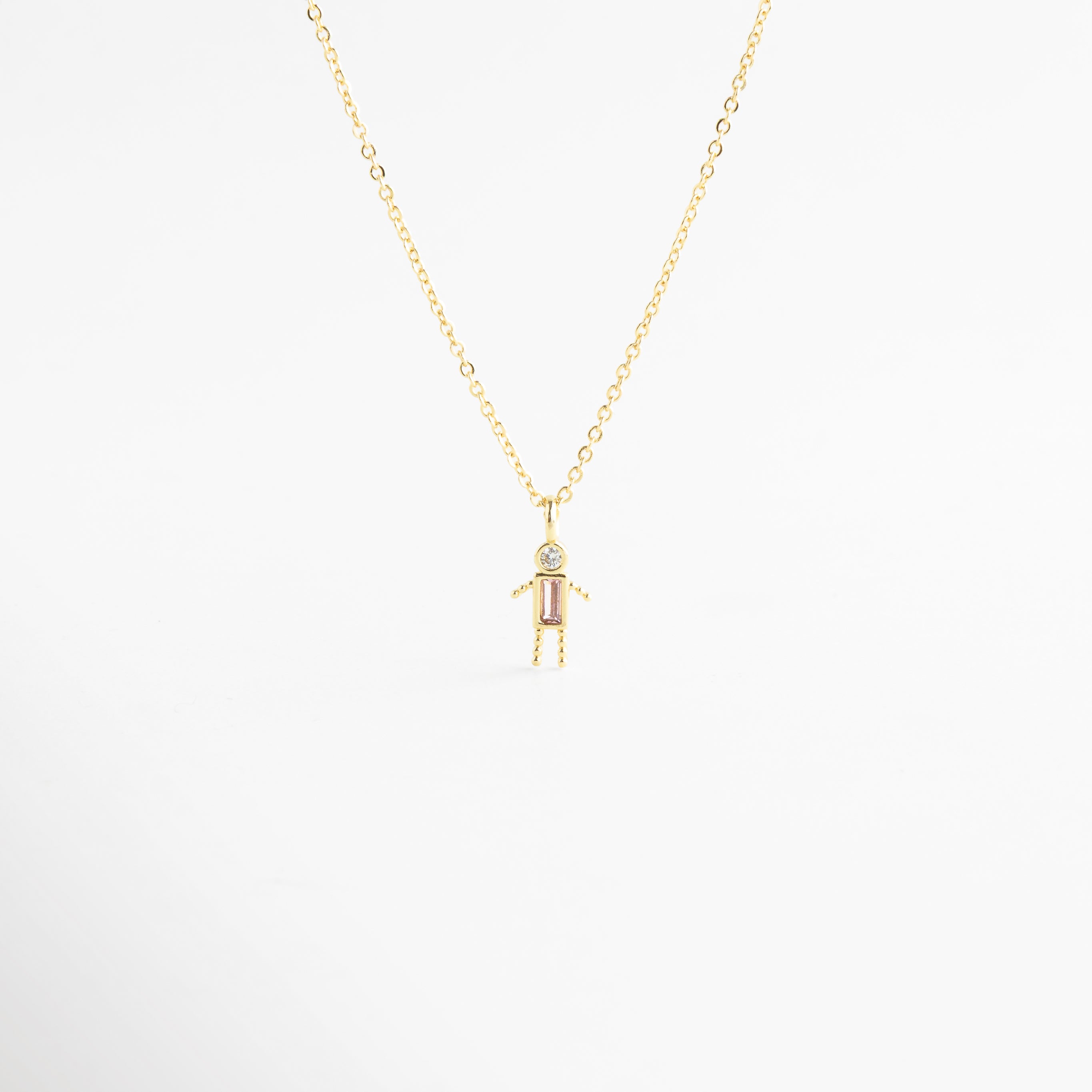 Collar dorado con dije de niño y zirconia rosa brillante, Collar delicado con colgante de niño y piedra rosa elegante, Collar en oro 18K con dije de niño y zirconia rosa, Collar fino dorado con figura de niño y detalle rosa, Collar con colgante pequeño de niño y zirconia rosa