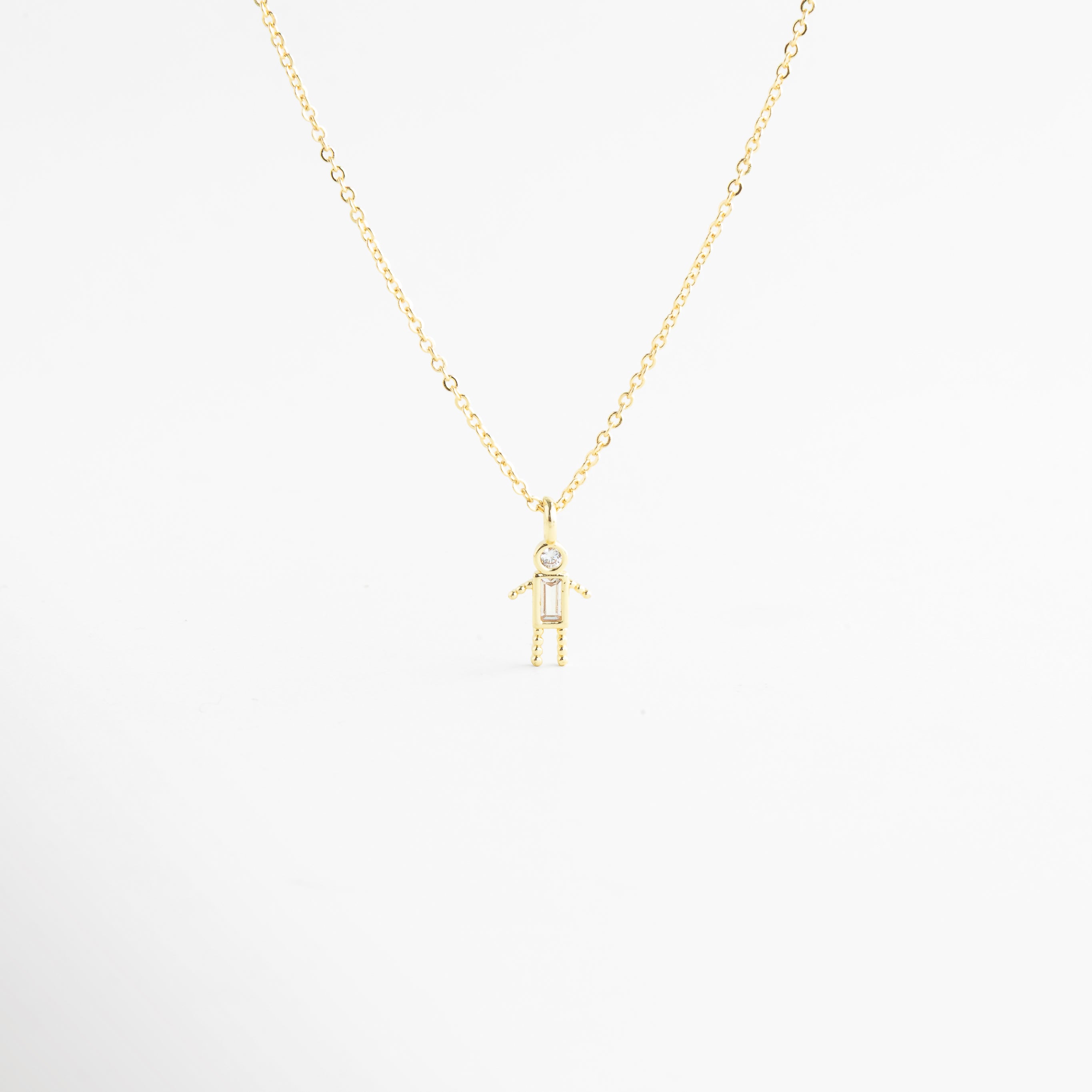 Collar dorado con dije de niño y zirconia cristal brillante, Collar delicado con colgante de niño y piedra transparente elegante, Collar en oro 18K con dije de niño y zirconia cristal, Collar fino dorado con figura de niño y detalle cristal, Collar con colgante pequeño de niño y zirconia transparente