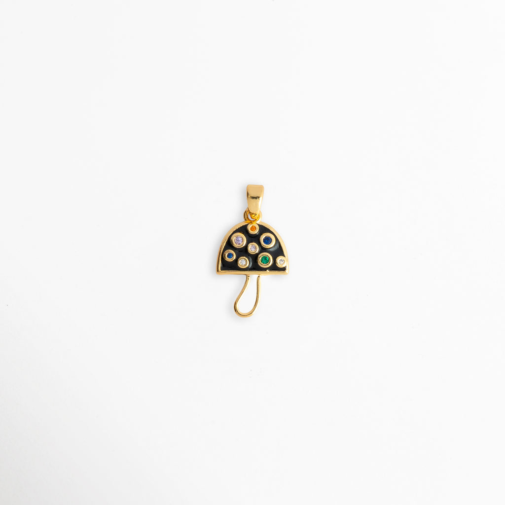 Charm Hongo Negro enchapado en oro 18K con sombrerillo de esmalte negro e incrustaciones de circonias multicolores, vista de frente sobre fondo blanco, Dije pequeño de hongo o seta con sombrero negro brillante, lunares de pedrería multicolor y talle estilizado dorado, Vista macro de charm en forma de hongo mágico de 2.1 x 1.2 cm enchapado en oro 18K con circonias en tonos azul, verde y blanco, Charm colgante místico de hongo negro con circonias incrustadas para cadena,