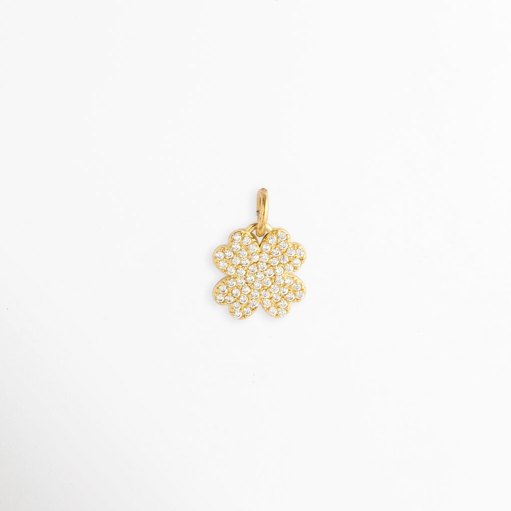 Charm Clover Spark enchapado en oro con pavé completo de circonias brillantes en forma de trébol de cuatro hojas, vista de frente sobre fondo blanco, Dije pequeño de trébol de cuatro hojas cubierto de incrustaciones de pedrería cristalina con argolla superior, Vista macro de charm amuleto de la suerte en forma de trébol de 1.8 x 1.2 cm enchapado en oro con micro pavé de circonias, Charm colgante de trébol dorado cuajado de circonias transparentes para cadena