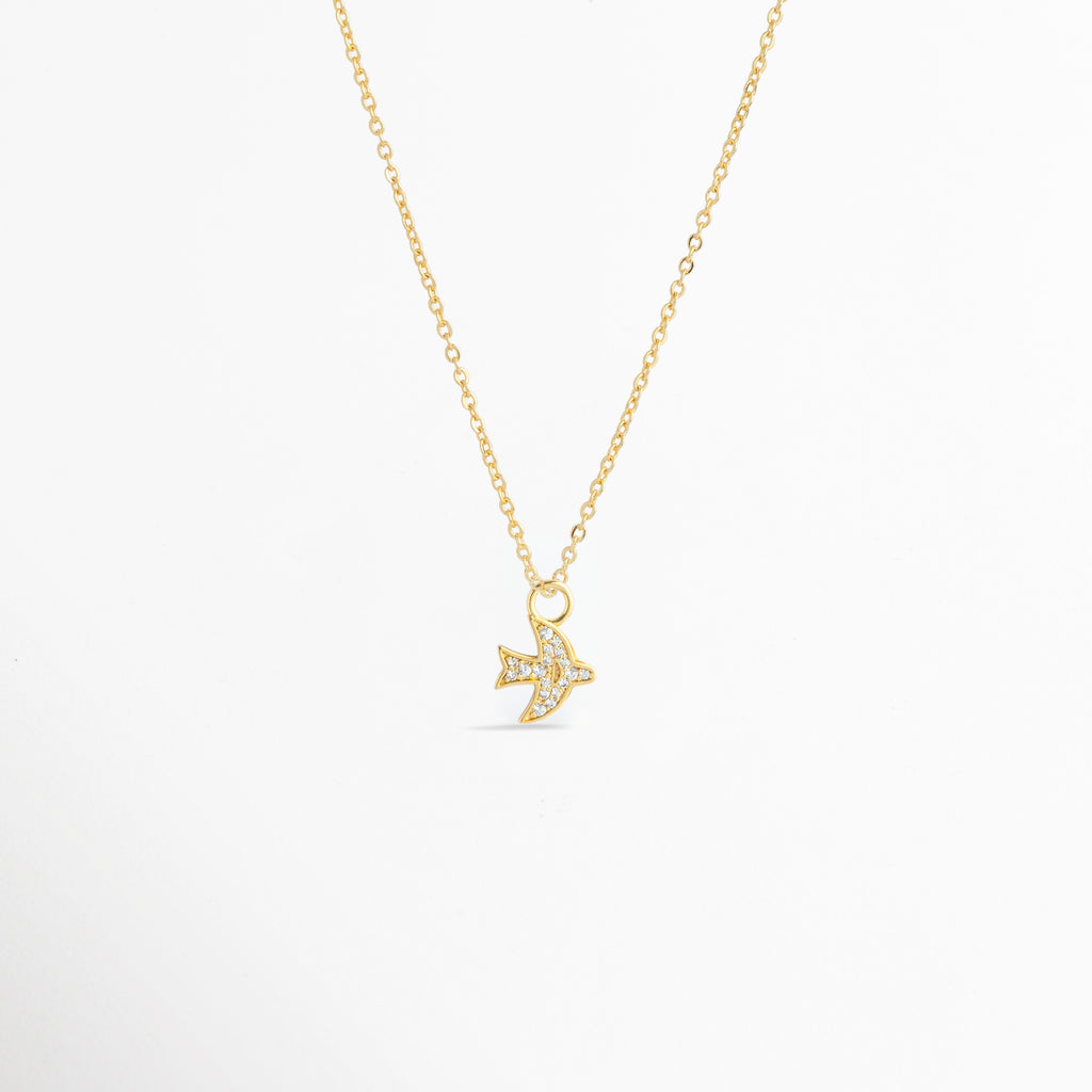 Charm Avión Zirconias montado como dije central en una fina cadena dorada sobre fondo blanco, Vista de collar con dije pequeño de avión enchapado en oro con circonias brillantes de 1.4 cm, Perspectiva de gargantilla delicada con dije colgante en forma de avión dorado con pedrería, Muestra de escala del charm de avión incrustado con circonias en una cadena delgada enchapada en oro.