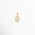 Charm Double Shimmer de cobre con acabado galvanizado dorado de 1.1 cm de largo y corte esmeralda en circonia transparente con reasa engastada, vista frontal sobre fondo blanco, Vista de frente de dije rectangular dorado con gran circonia cristalina central de corte radiante y reasa con pavé de pedrería, Plano general de charm elegante con gema transparente de corte esmeralda de 0.7 cm de ancho y bisel dorado de alto brillo, Charm Double Shimmer destacando el doble 