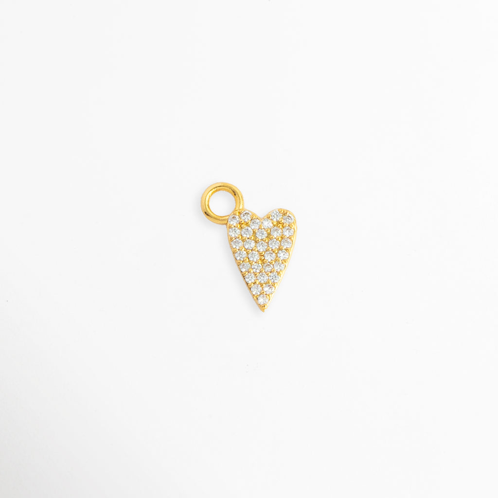Charm Corazón Zirconias enchapado en oro con pavé de circonias brillantes transparentes en silueta estilizada, vista de frente sobre fondo blanco, Dije pequeño en forma de corazón alargado con incrustaciones de pedrería cristalina y argolla superior, Vista macro de charm en forma de corazón de 1.2 x 0.7 cm enchapado en oro con micro pavé de circonias, Charm colgante romántico de corazón dorado con circonias cristalinas para cadena, pulsera o arracada.