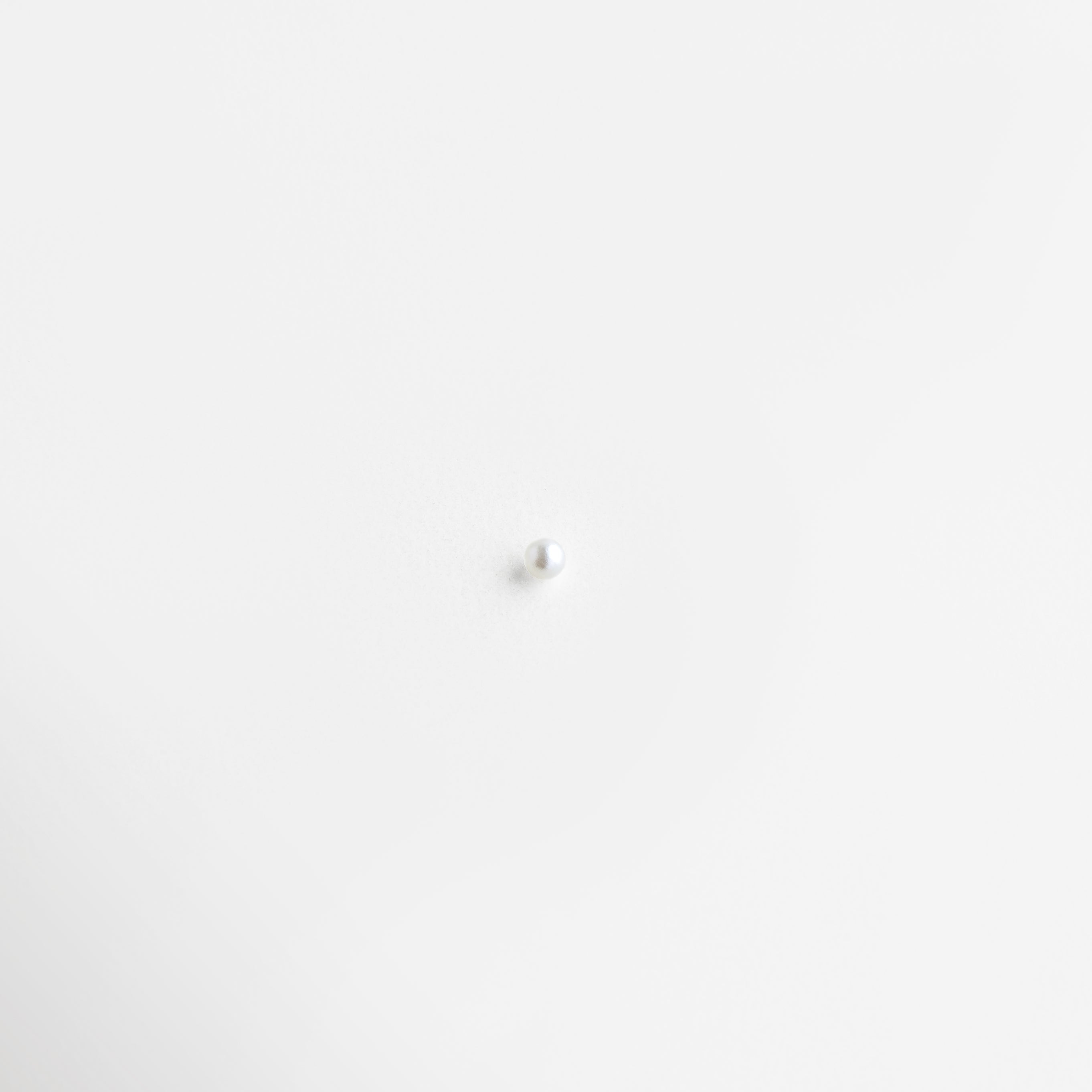 Charm de perla blanca con acabado brillante y diseño elegante, Charm perla clásica con estilo minimalista y brillo sofisticado, Charm de perla con diseño delicado y acabado luminoso, Charm perla blanca elegante con estilo atemporal femenino, Charm de perla con acabado suave y brillo natural