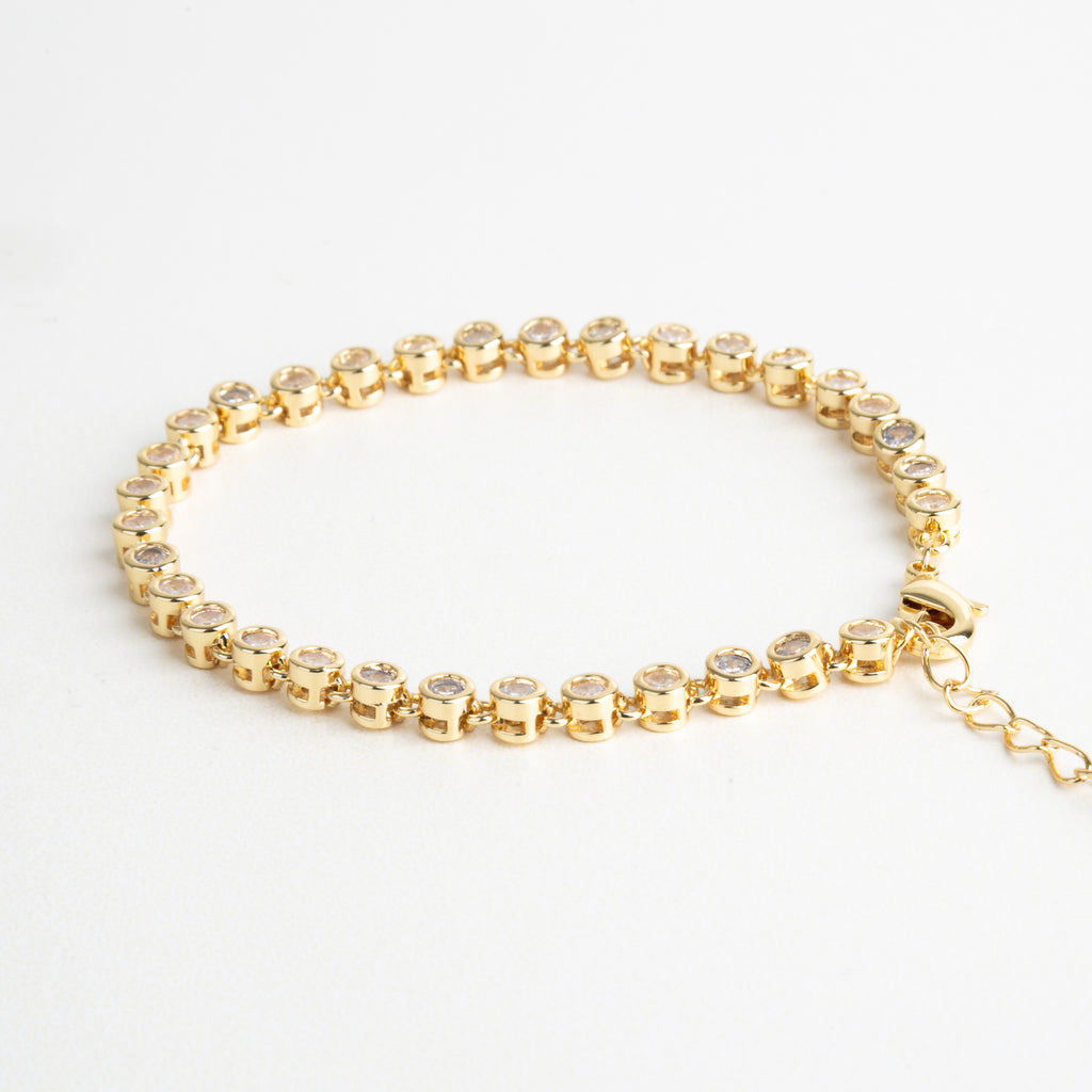 Pulsera dorada con zirconias cúbicas transparentes, Joya elegante con diseño delicado y acabado brillante, Pulsera fina en chapa de oro con detalles luminosos, Complemento sofisticado para looks frescos y modernos, Diseño dorado con incrustaciones sutiles de zirconia