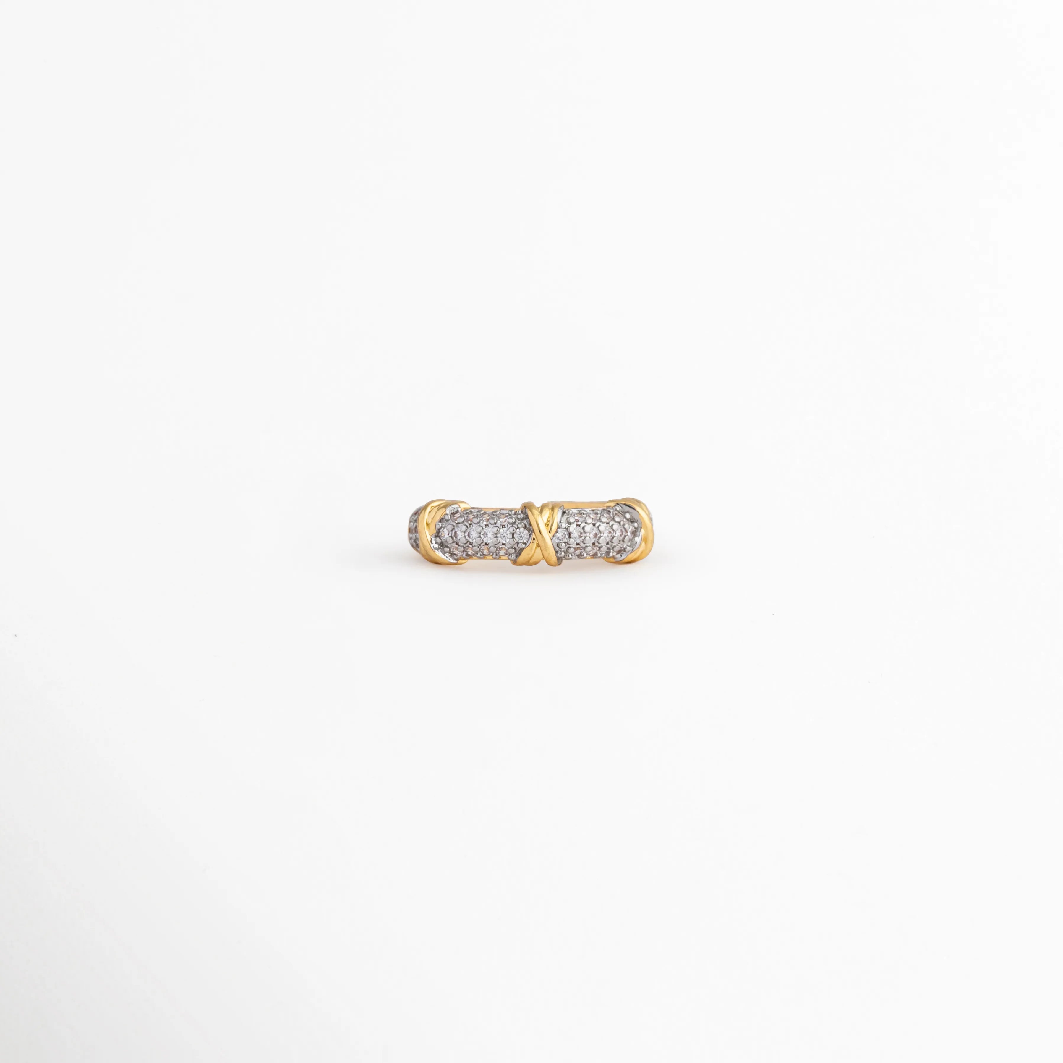 Perfil de anillo Kira con zirconias incrustadas y acabado en oro 18K, Vista lateral de anillo ajustable dorado con detalles brillantes de zirconia, Anillo de cobre chapado en oro con diseño clásico y piedras de zirconia, Detalle lateral de anillo elegante con acabado pulido y zirconias, Anillo ajustable con incrustaciones de zirconia visto de perfil