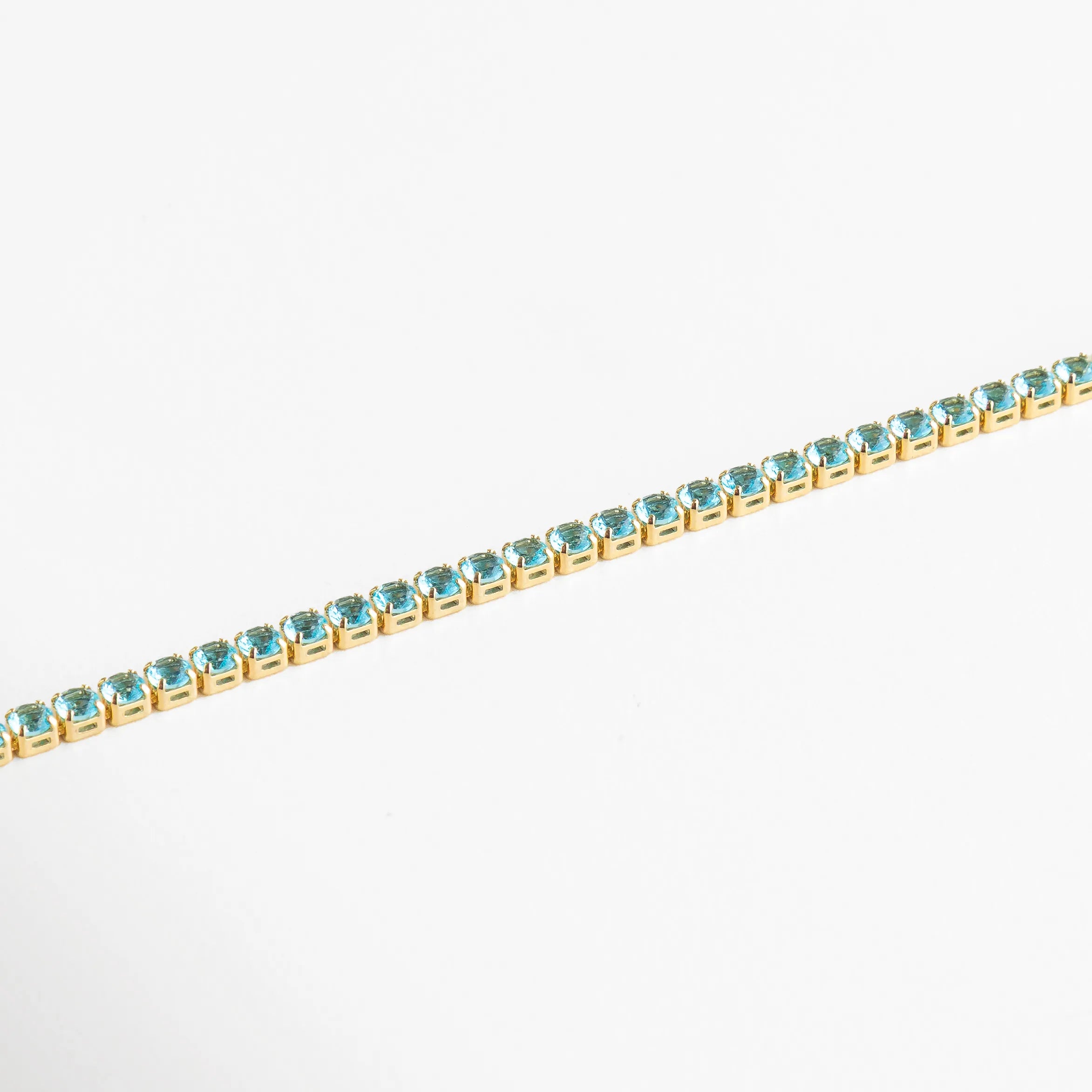 Cristales azules perfectamente alineados sobre base dorada, reflejando luz con cada movimiento.