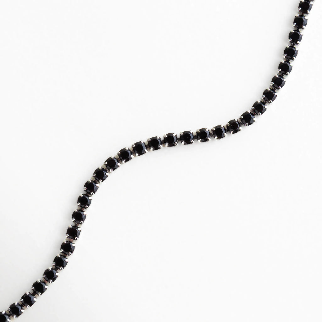 Vista en forma ondulada que resalta el brillo profundo de los cristales negros sobre base plateada.