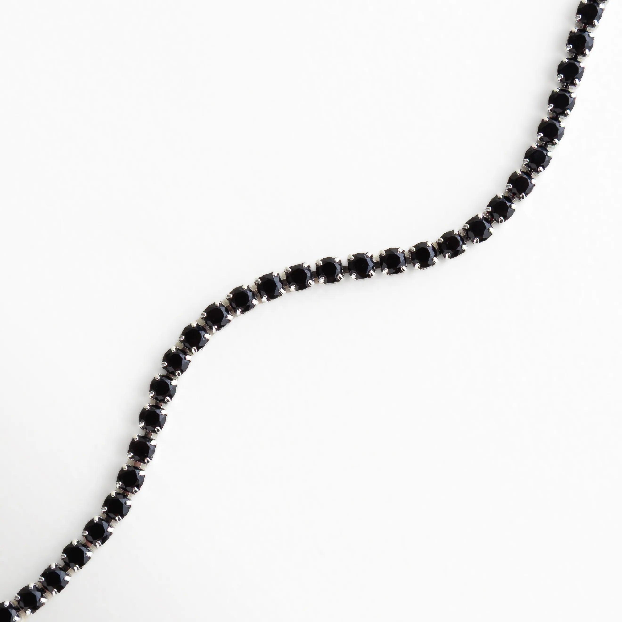 Vista en forma ondulada que resalta el brillo profundo de los cristales negros sobre base plateada.