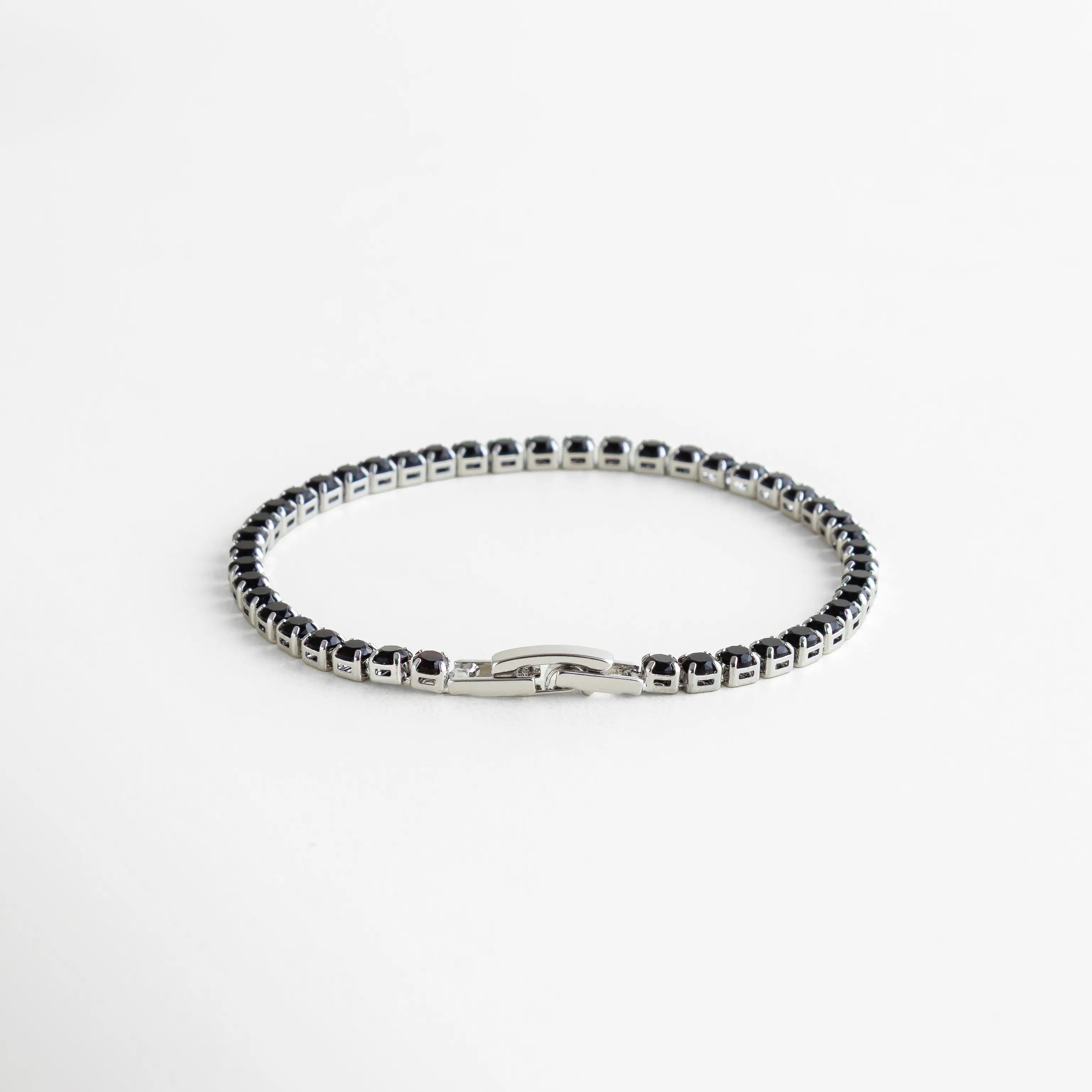 Pulsera de cristales negros estilo tennis, ideal para añadir un toque moderno y sofisticado al look.