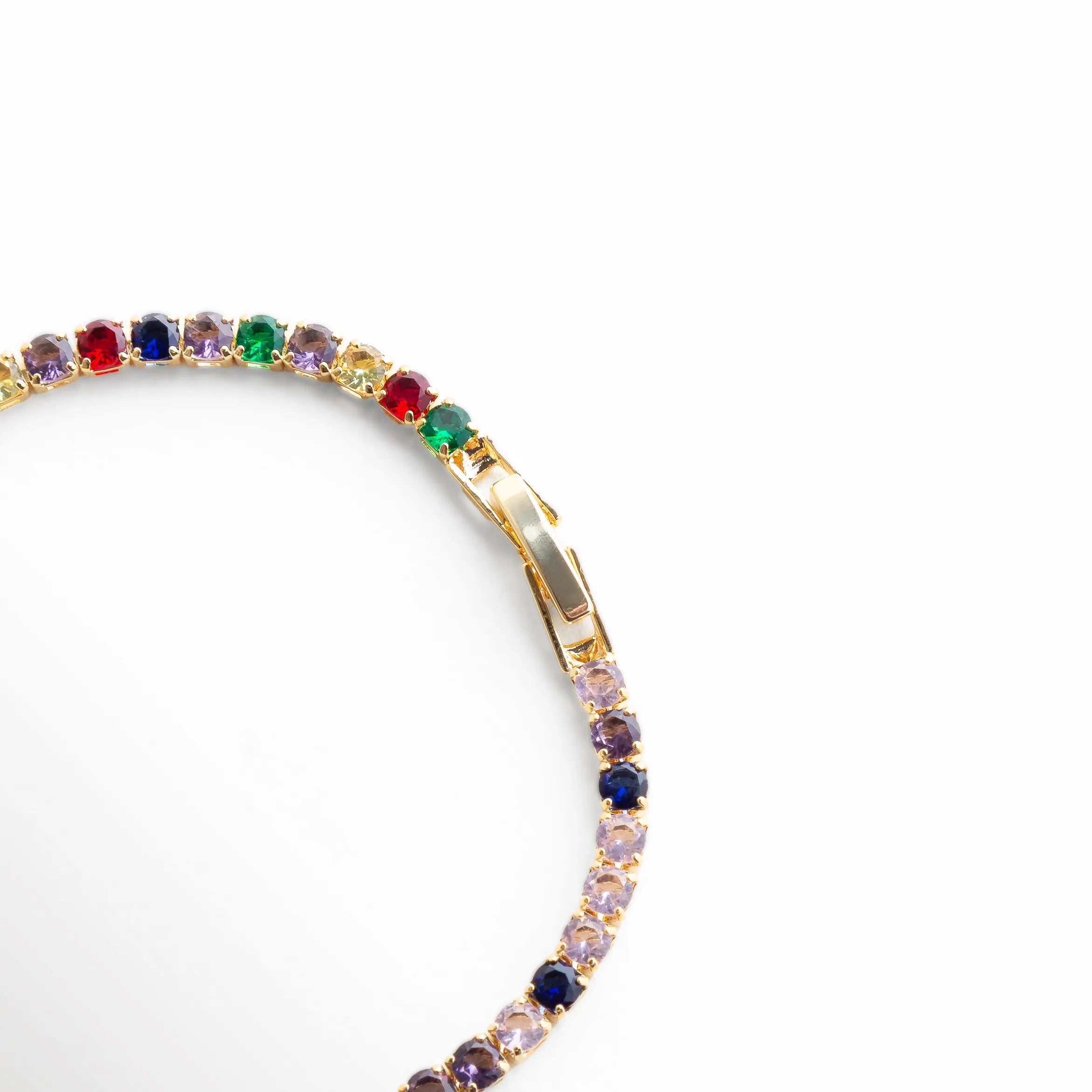 Vista parcial de pulsera dorada con zirconias multicolor en curva, Detalle de pulsera con piedras de colores y acabado enchapado en oro 18K, Pulsera con zirconias vibrantes en diseño elegante y moderno, Segmento de pulsera con brillo multicolor y estructura fina, Close-up lateral de pulsera tipo tenis con zirconias de colores