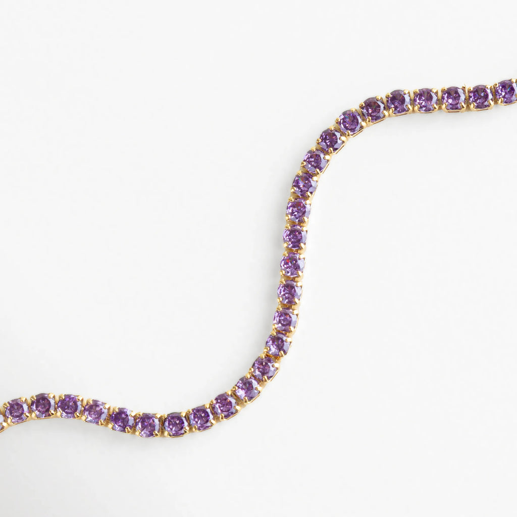 Cristales morados perfectamente alineados sobre base dorada, reflejando tonos suaves y luminosos.