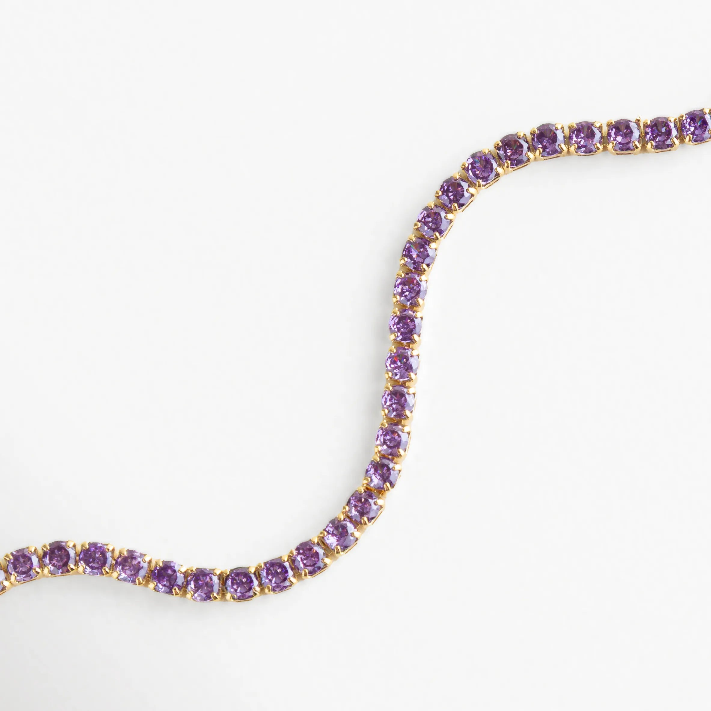 Cristales morados perfectamente alineados sobre base dorada, reflejando tonos suaves y luminosos.