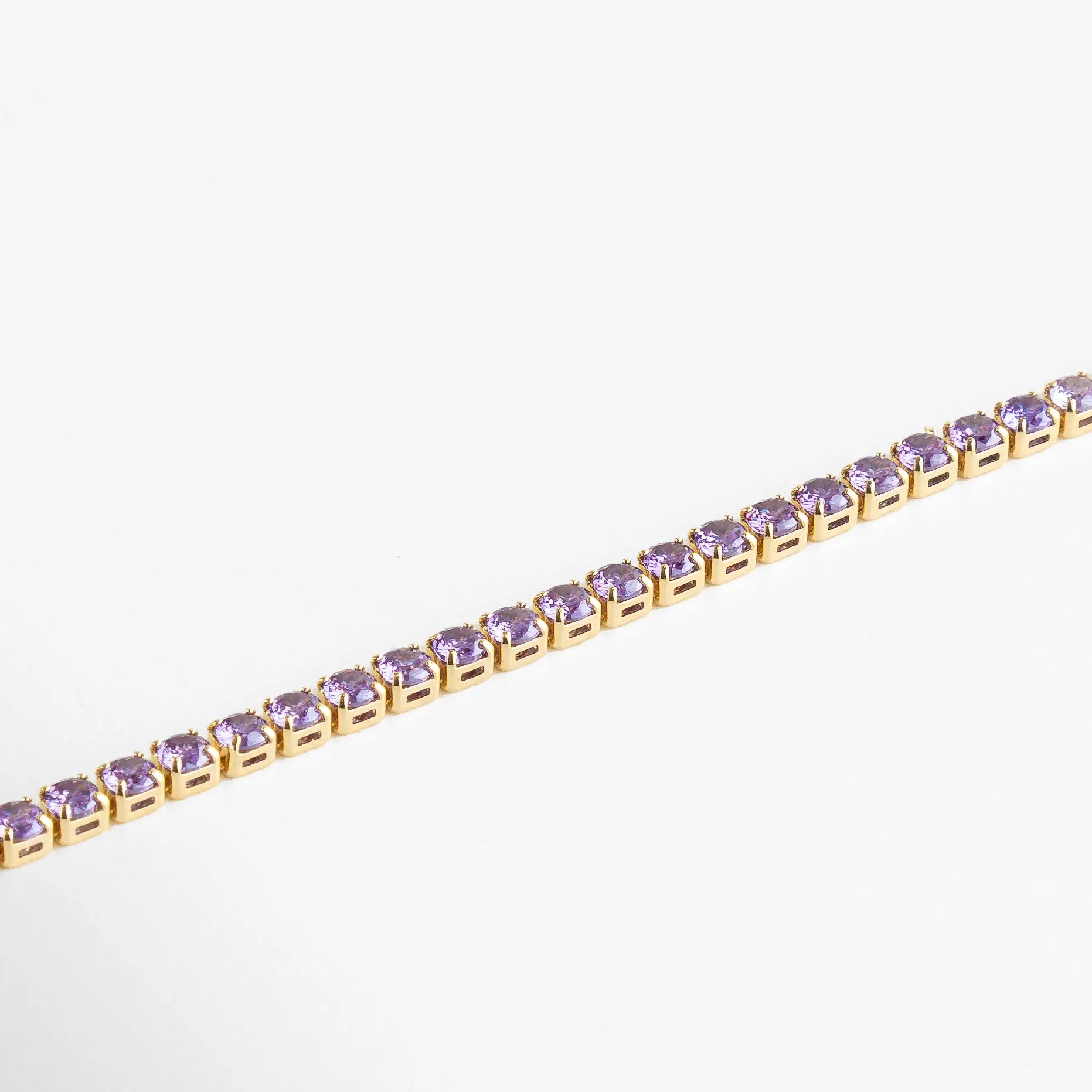 Estructura dorada con cristales redondos en tono violeta, mostrando su brillo y acabado impecable.