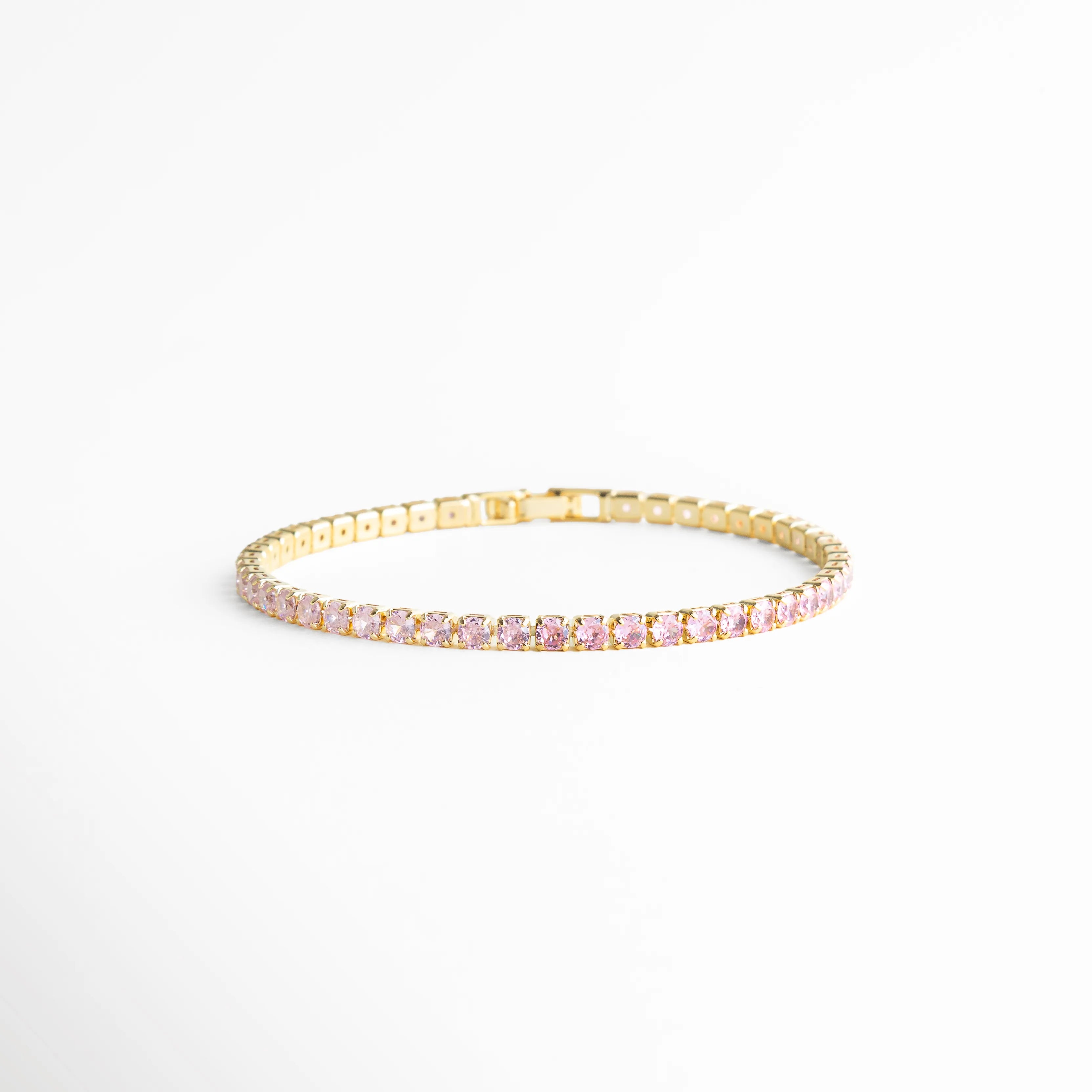 Pulsera tipo tenis multicolor en línea recta con zirconias y acabado oro 18K, Pulsera delgada con piedras de colores alineadas sobre fondo claro, Vista lateral de pulsera con zirconias multicolor en diseño continuo, Pulsera elegante de 18 cm con brillo uniforme y acabado dorado, Diseño minimalista de pulsera con zirconias arcoíris en base de cobre