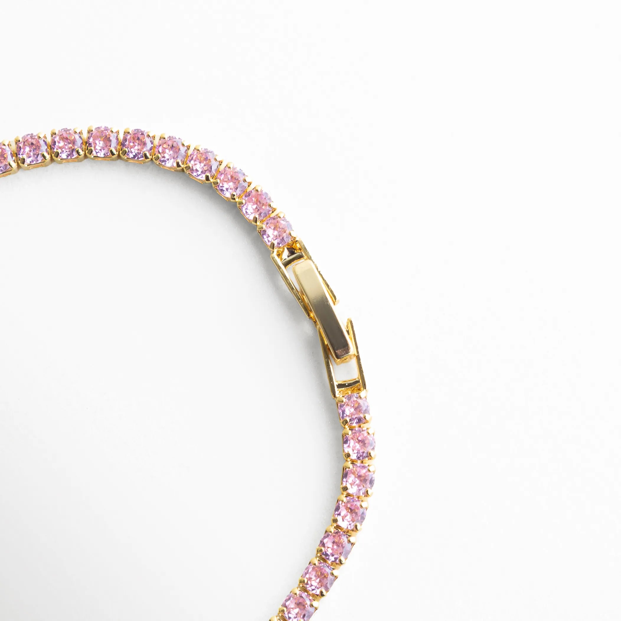 Detalle de broche en pulsera dorada con zirconias multicolor, Cierre de pulsera tipo tenis con acabado oro 18K y ajuste seguro, Vista cercana del broche metálico en pulsera elegante, Pulsera con sistema de cierre resistente y acabado brillante, Detalle de unión y cierre en pulsera con zirconias de colores