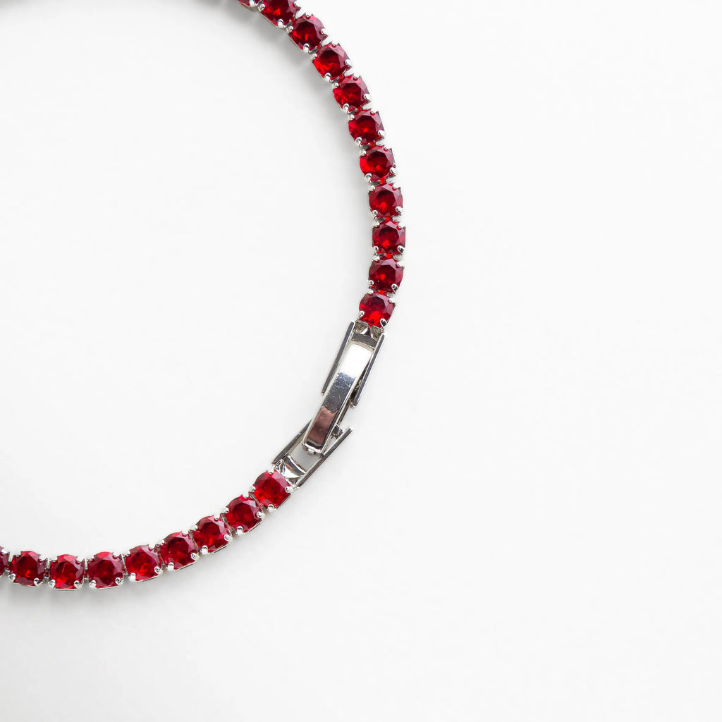 Cierre seguro de la pulsera con acabado plateado y cristales en tono rubí, ideal para complementar looks elegantes.
