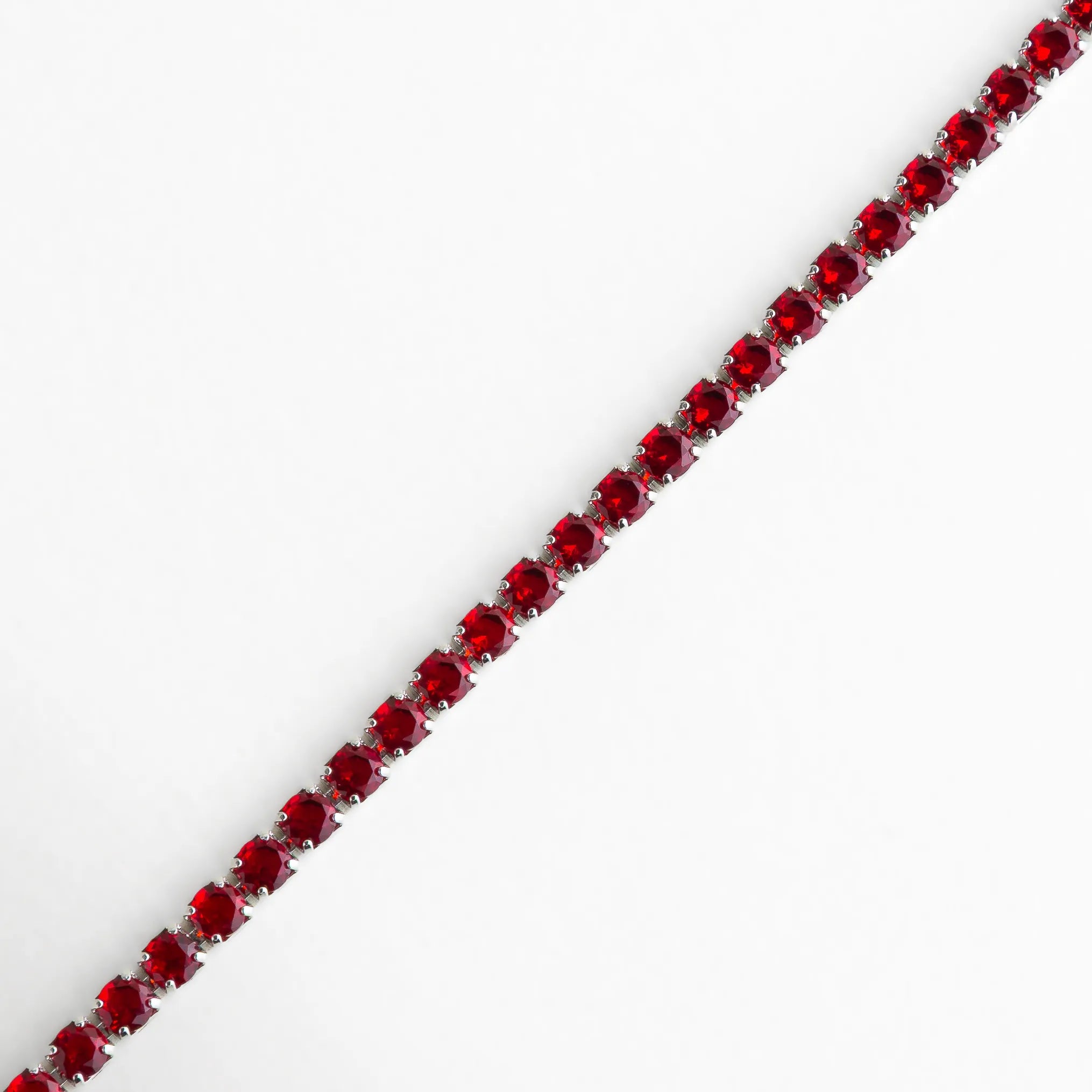 Vista cercana del engaste de cristales rojos, mostrando su brillo intenso y precisión artesanal.