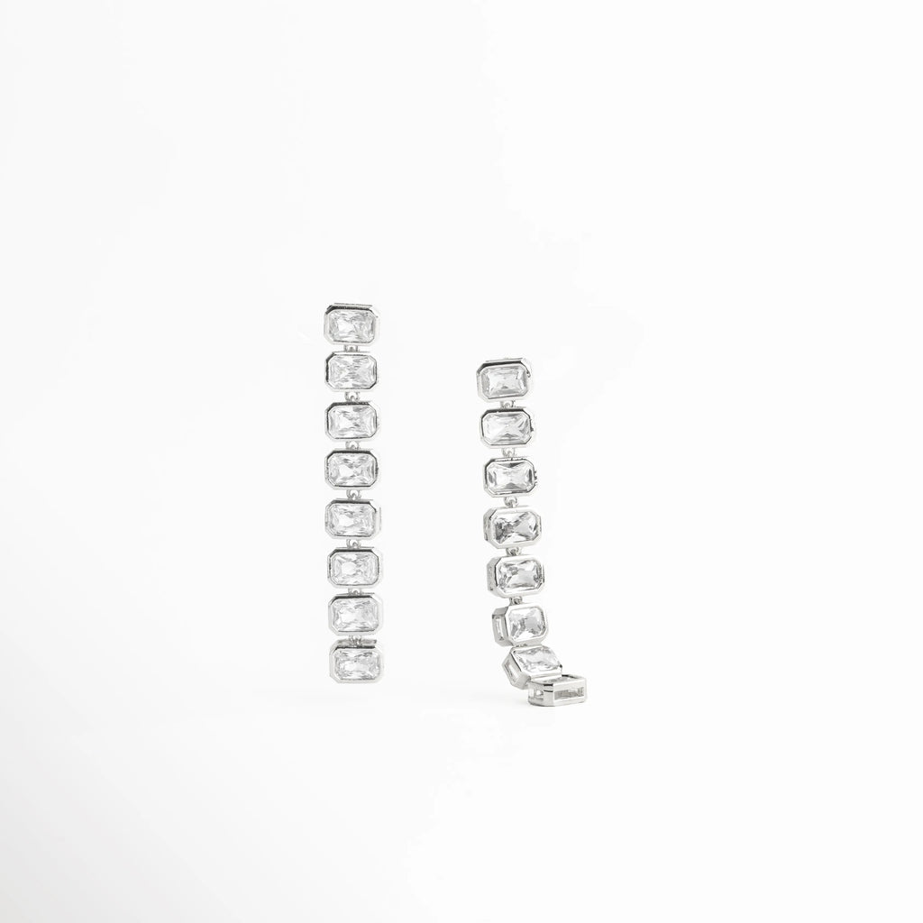 aretes plateados vista frontal, aretes largos elegantes, joyería plateada moderna, aretes con brillo continuo, accesorios femeninos plateados, aretes chic mujer, joyería contemporánea, aretes refinados