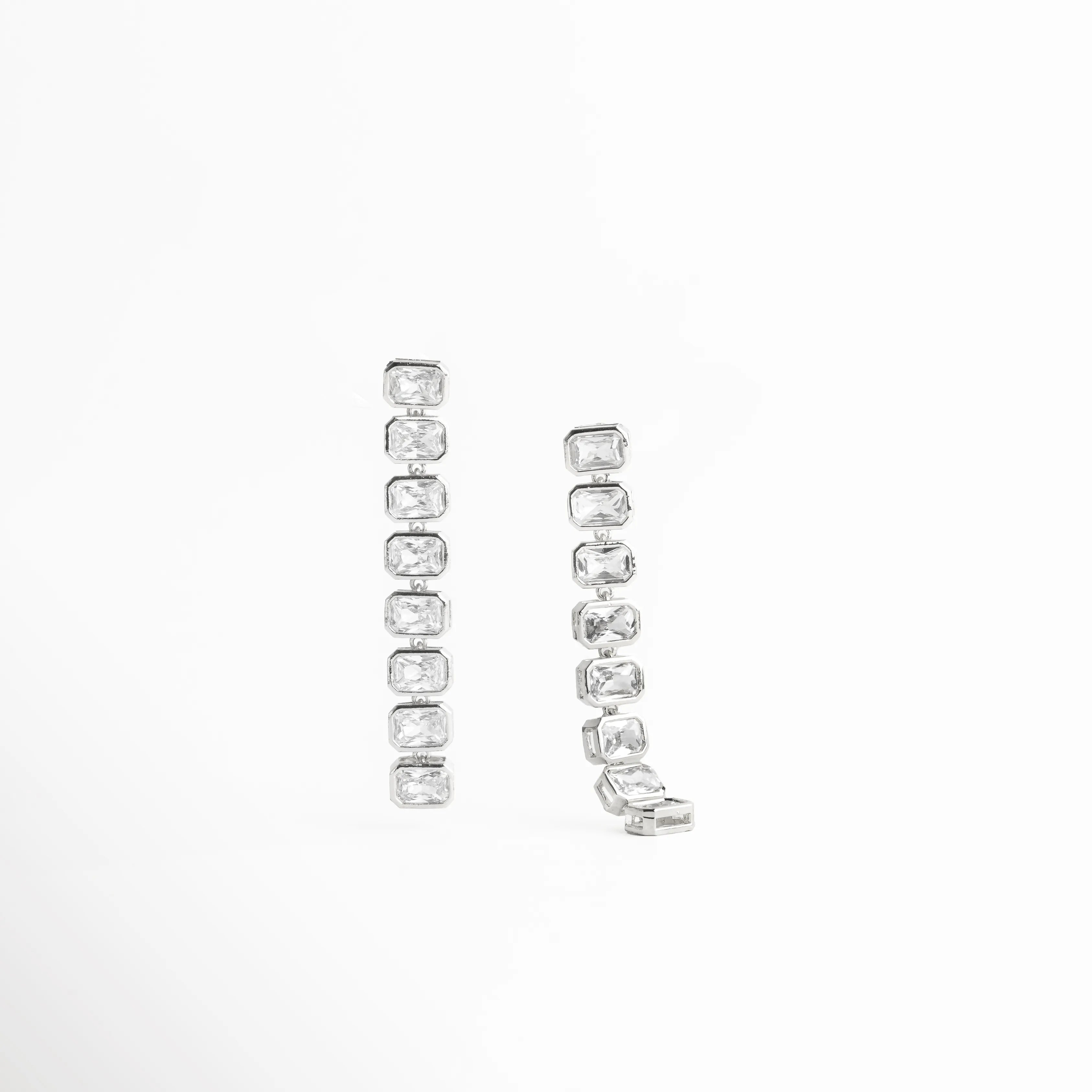 aretes plateados vista frontal, aretes largos elegantes, joyería plateada moderna, aretes con brillo continuo, accesorios femeninos plateados, aretes chic mujer, joyería contemporánea, aretes refinados