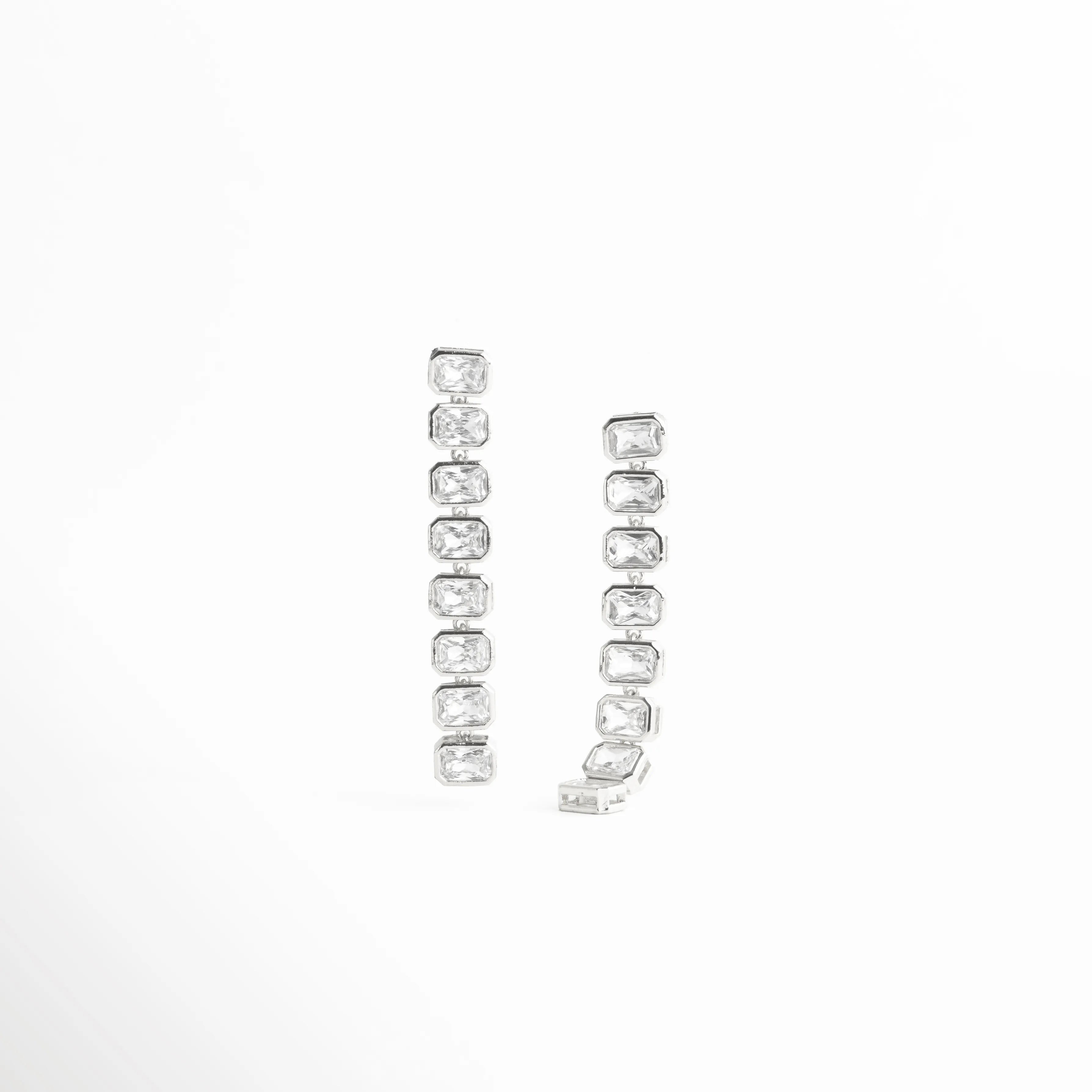 aretes largos plateados, aretes con piedras alineadas, joyería plateada elegante, aretes colgantes modernos, accesorios plateados sofisticados, aretes brillantes mujer, joyería luminosa, aretes estilizados