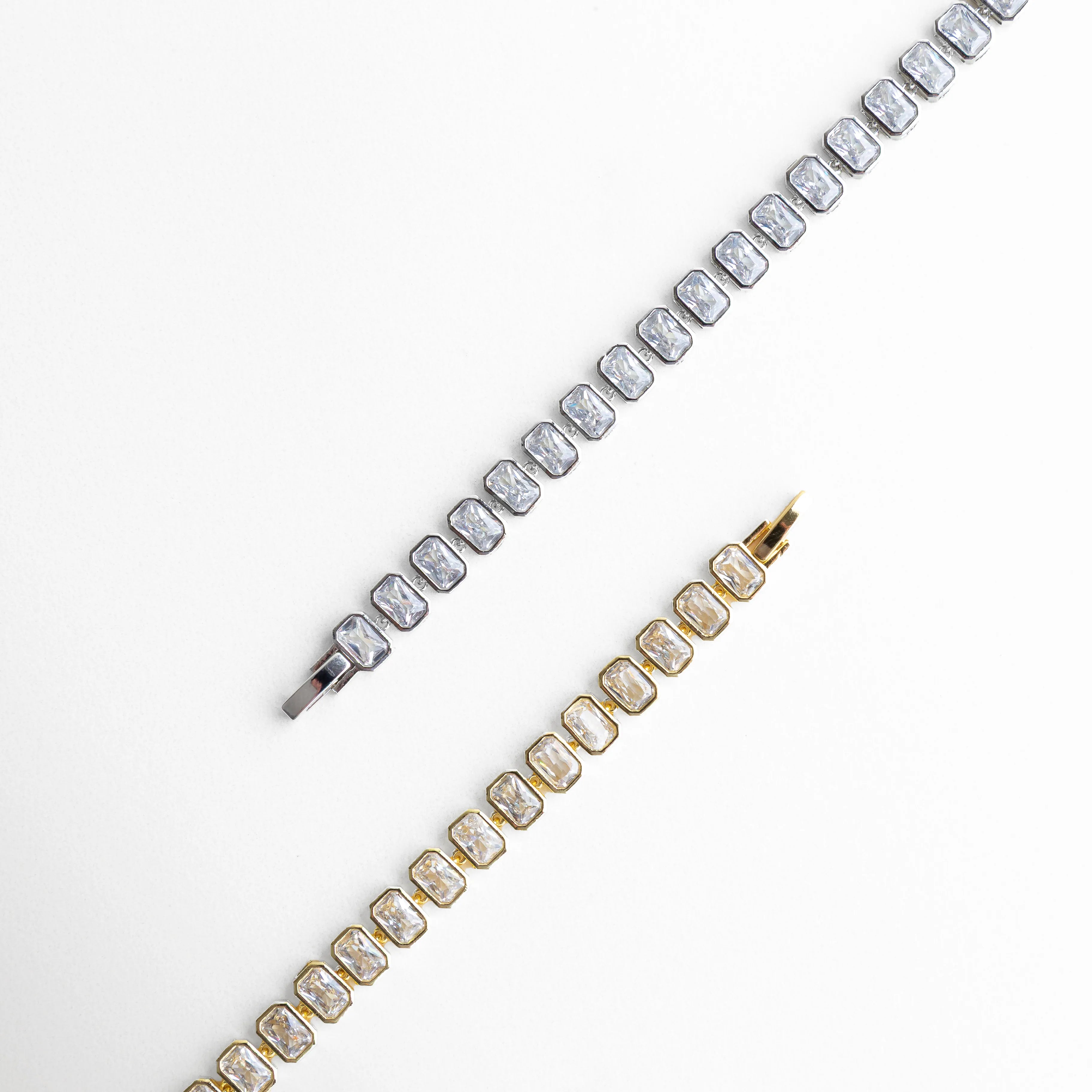 Pulsera tipo tenis en acabado plateado y dorado con zirconias brillantes, Comparación de pulseras elegantes en oro blanco y dorado, Dos versiones de pulsera con zirconias, plateada y dorada, Pulsera Jung en diferentes tonos con diseño sofisticado, Vista comparativa de pulsera con acabado plateado y dorado