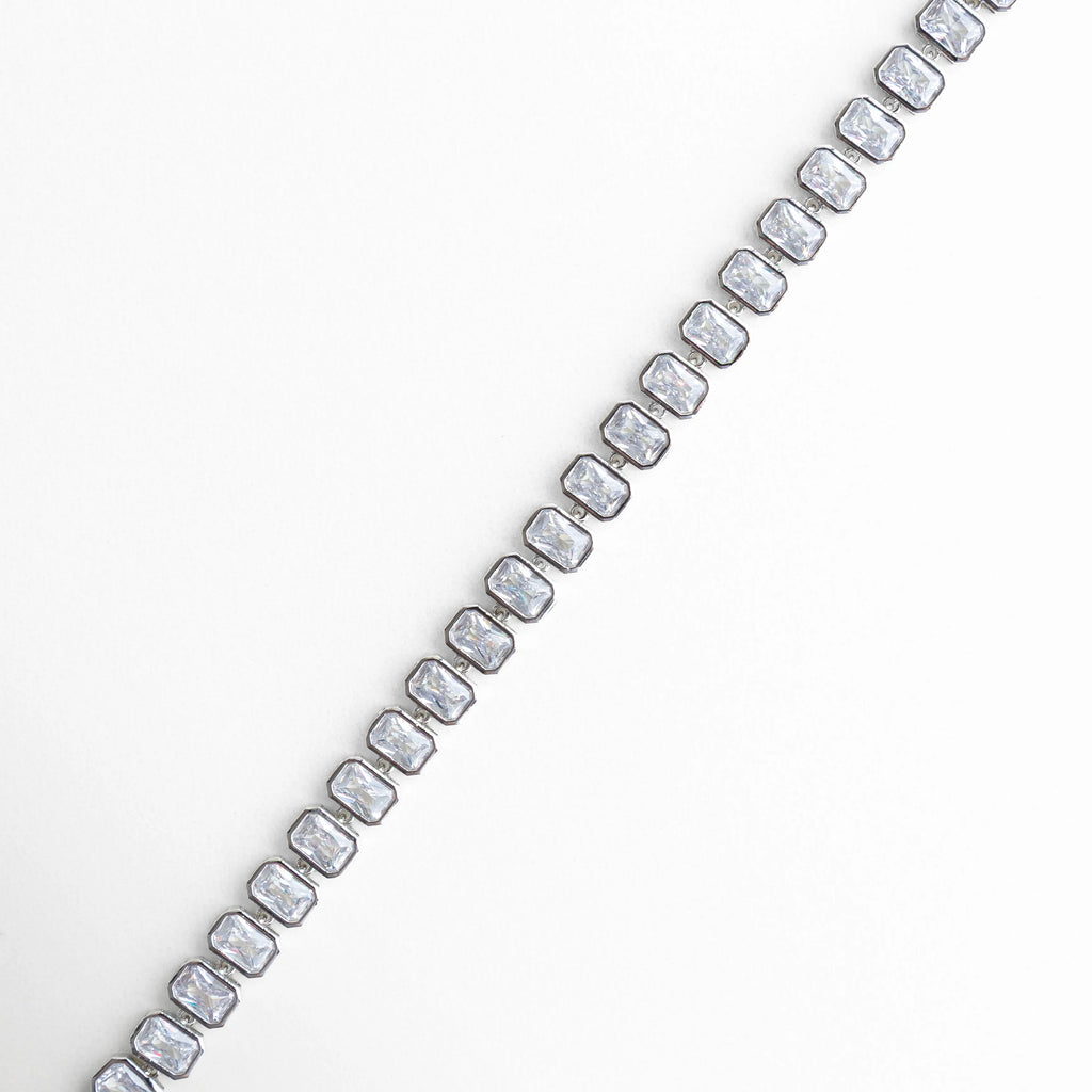 Vista lateral de pulsera con zirconias en línea continua, Perfil de pulsera tipo tenis con piedras brillantes y diseño fino, Pulsera vista de lado con estructura elegante y zirconias, Lateral de pulsera plateada con incrustaciones brillantes, Detalle lateral con alineación perfecta de zirconias