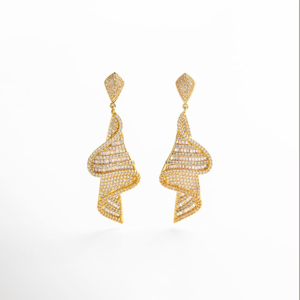 aretes largos dorados con zirconias brillantes, diseño glamuroso de aretes statement en chapa de oro, vista completa de aretes con caída elegante, par de aretes dorados con forma alargada y movimiento, joyería dorada de noche con incrustaciones luminosas