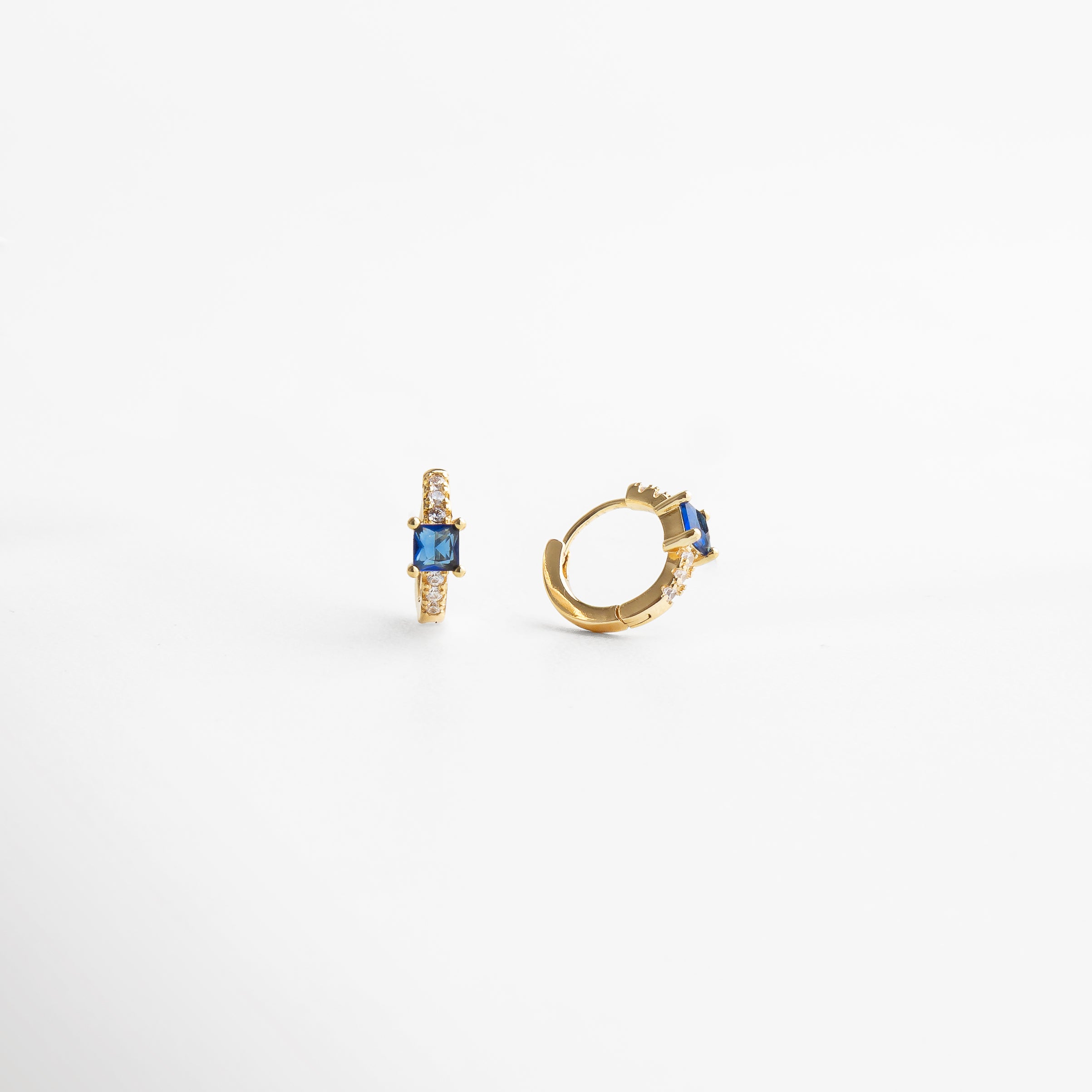 Cierre seguro en aretes hoops dorados con zirconias y piedra zafiro, diseño cómodo y resistente, joyería refinada ideal para uso diario o eventos especiales