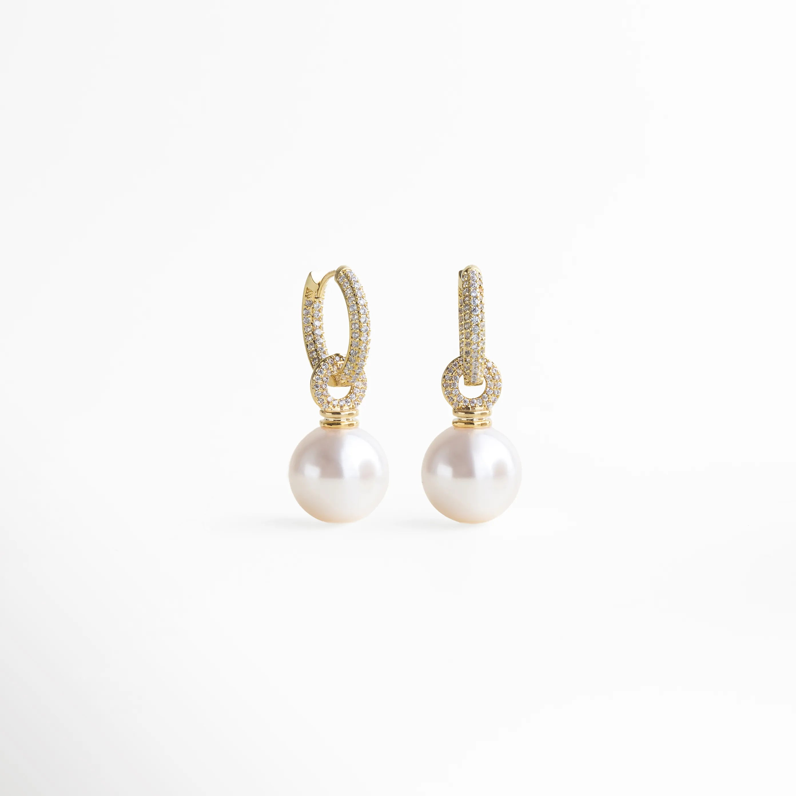 aretes de perla vista lateral, detalle aro dorado, joyería elegante mujer, aretes con diseño refinado, accesorios dorados sofisticados, aretes perla modernos, joyería clásica femenina, aretes delicados elegantes