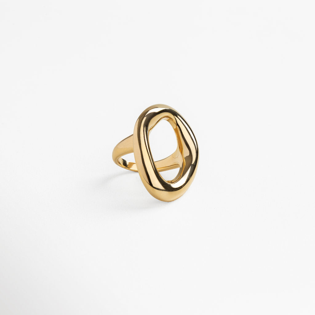 Anillo dorado con diseño curvo visto de perfil, Silueta ancha y elegante del Anillo Donna en ángulo, Joya contemporánea dorada en vista diagonal, Diseño moderno del anillo dorado desde un lateral