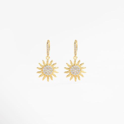 Aretes colgantes dorados vistos en ángulo con brillo de zirconias, Detalle lateral de pendientes largos en oro con piedras, Aretes de chapa de oro vistos de perfil con destellos, Vista lateral de aretes sunrise con forma elegante, Pendientes curvos dorados con movimiento y luz