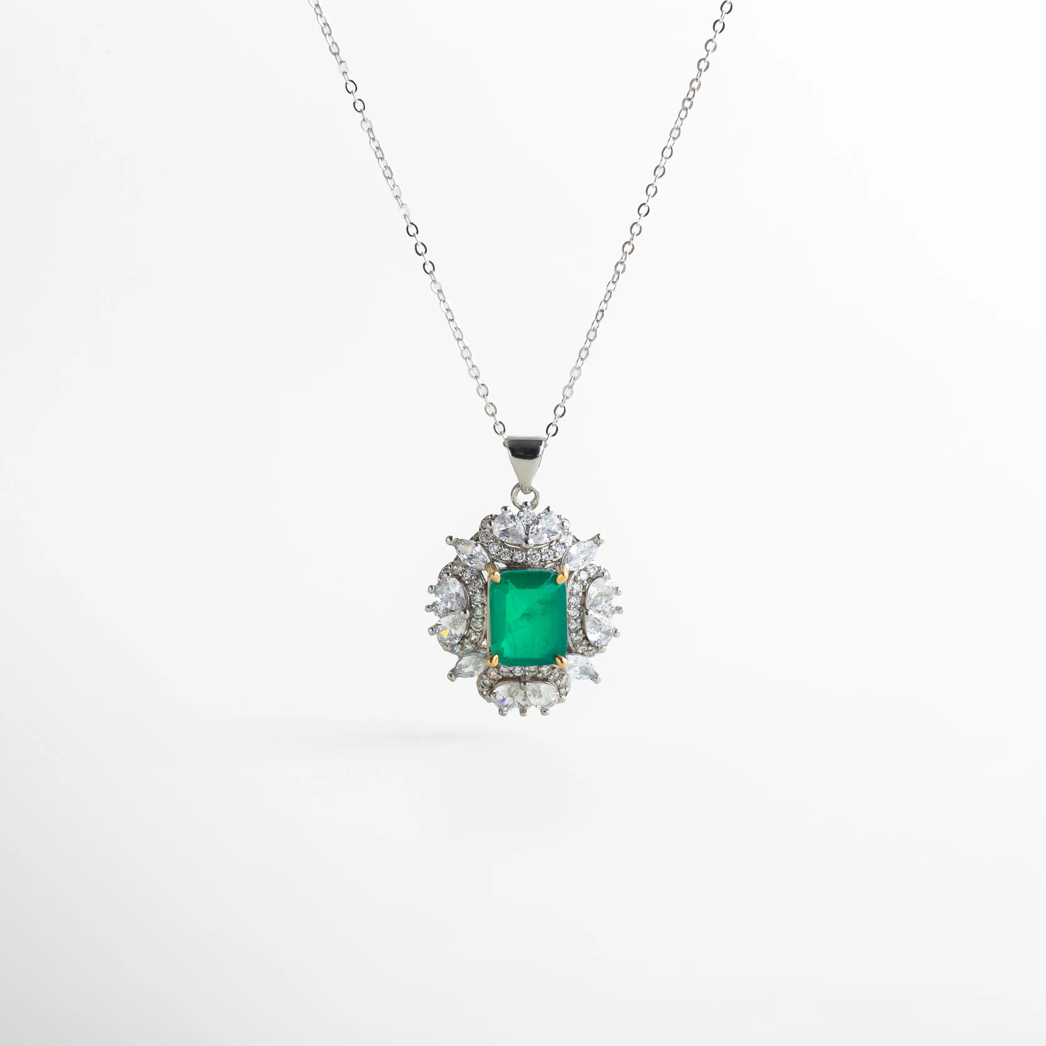 Collar plateado con colgante central inspirado en la elegancia clásica, con piedra verde esmeralda de corte rectangular rodeada por zirconias transparentes. Su diseño simétrico y brillo radiante evocan lujo atemporal y sofisticación.