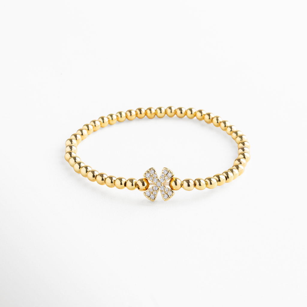 Pulsera elástica de cobre con recubrimiento enchapado en oro 18K e incrustaciones de zirconias, diseño de cuentas doradas con dije en forma de letra X personalizada, joya delicada y versátil de 1 x 0.7 cm ideal para uso diario.