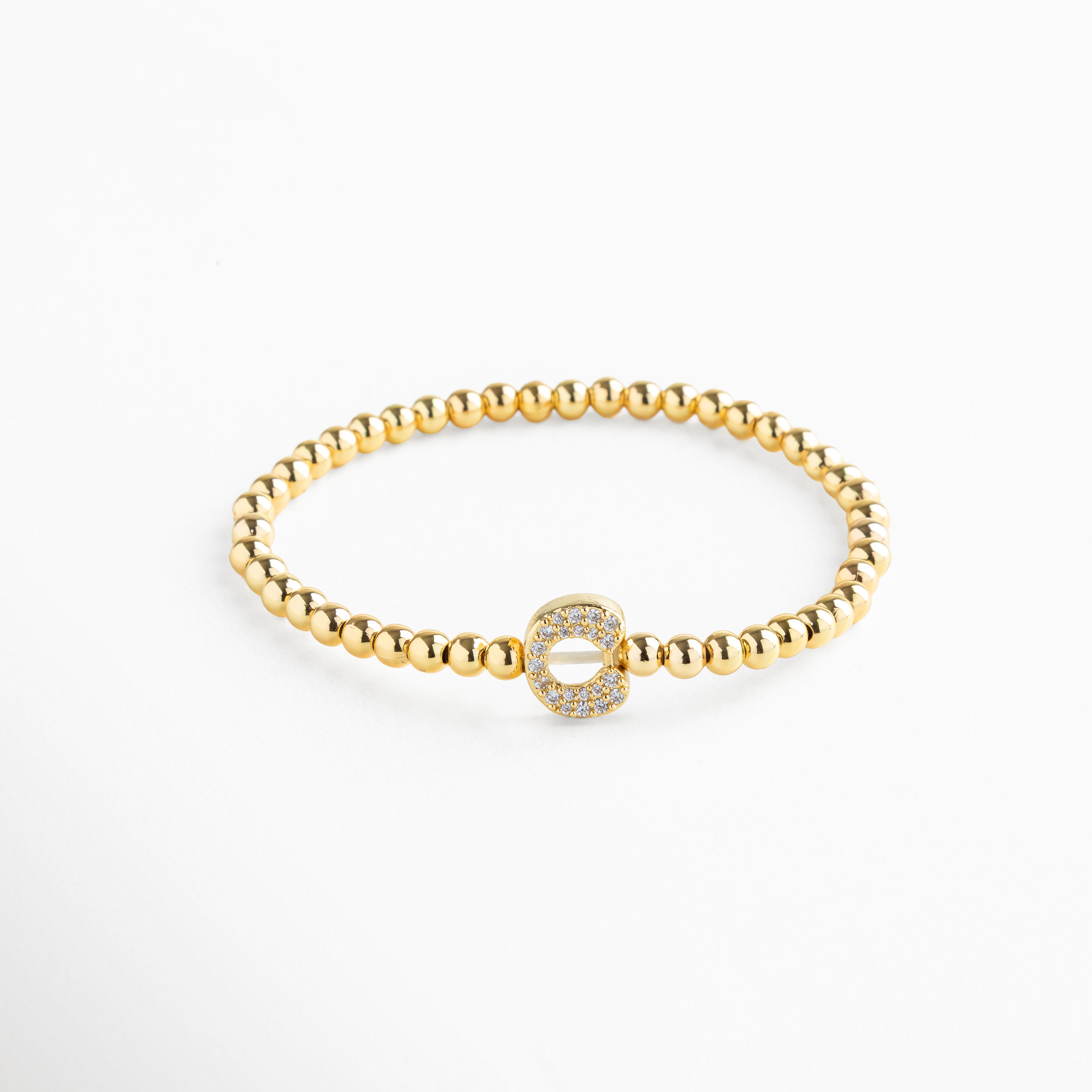 Pulsera elástica de cobre con recubrimiento enchapado en oro 18K e incrustaciones de zirconias, diseño de cuentas doradas con dije en forma de letra C personalizada, joya delicada y versátil de 1 x 0.7 cm ideal para uso diario.
