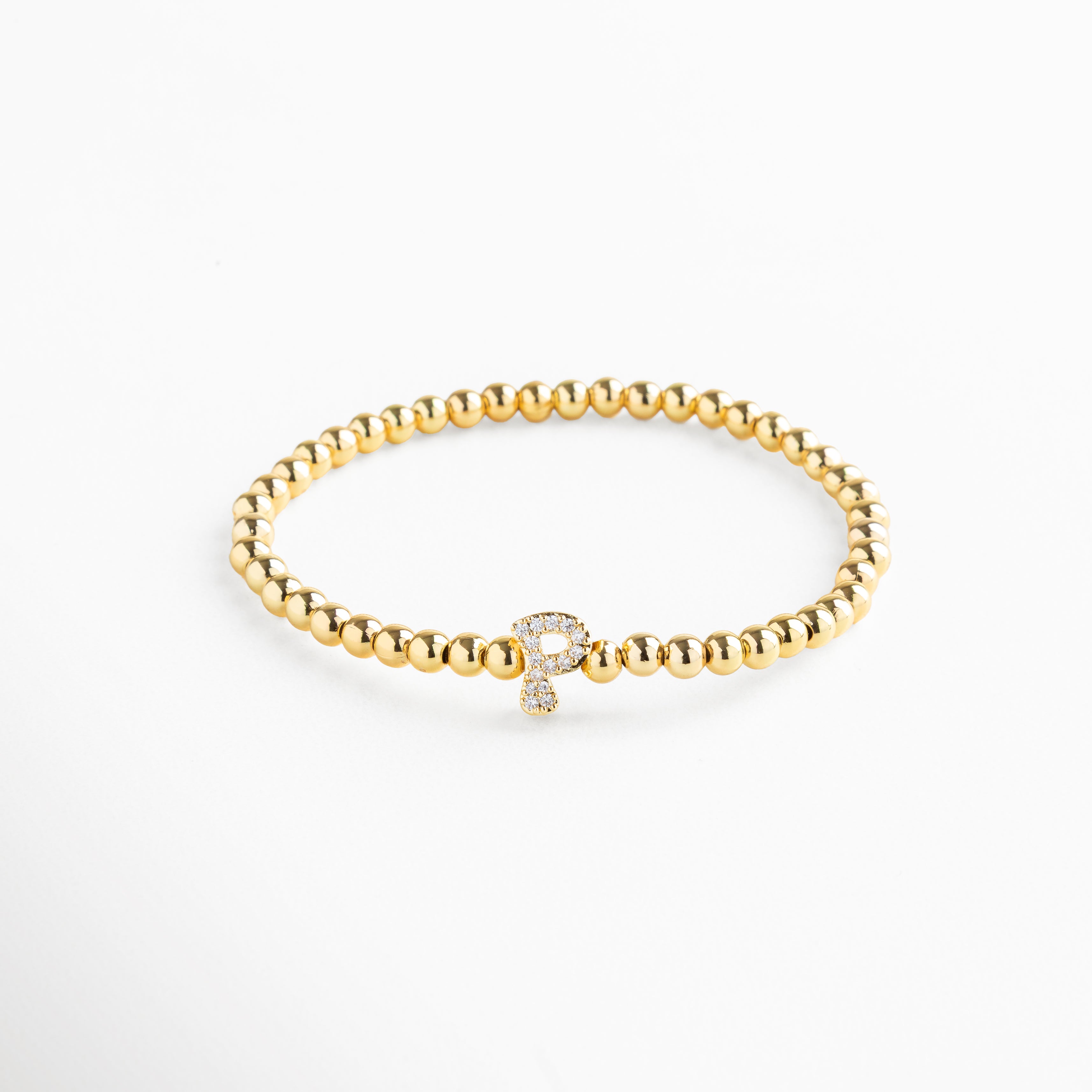 Pulsera elástica de cobre con recubrimiento enchapado en oro 18K e incrustaciones de zirconias, diseño de cuentas doradas con dije en forma de letra P personalizada, joya delicada y versátil de 1 x 0.7 cm ideal para uso diario.