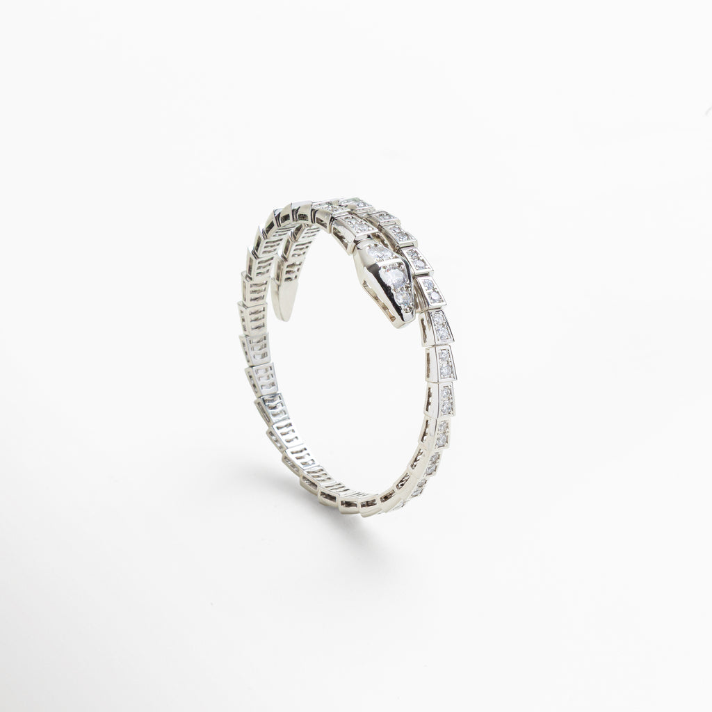 Acercamiento a la estructura flexible y articulada de la pulsera, Diseño envolvente que se adapta a la muñeca con estilo, Brillo intenso de las zirconias cúbicas incrustadas en escamas, Cierre oculto con forma de serpiente, elegante y seguro, Grosor y ancho del brazalete visible en primer plano