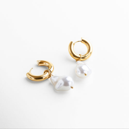 Detalle del broche de perla desmontable en arete dorado, Textura de perla barroca de imitación en pendiente dorado, Primer plano de la perla colgante sobre base dorada, Acabado pulido en dorado con perla removible